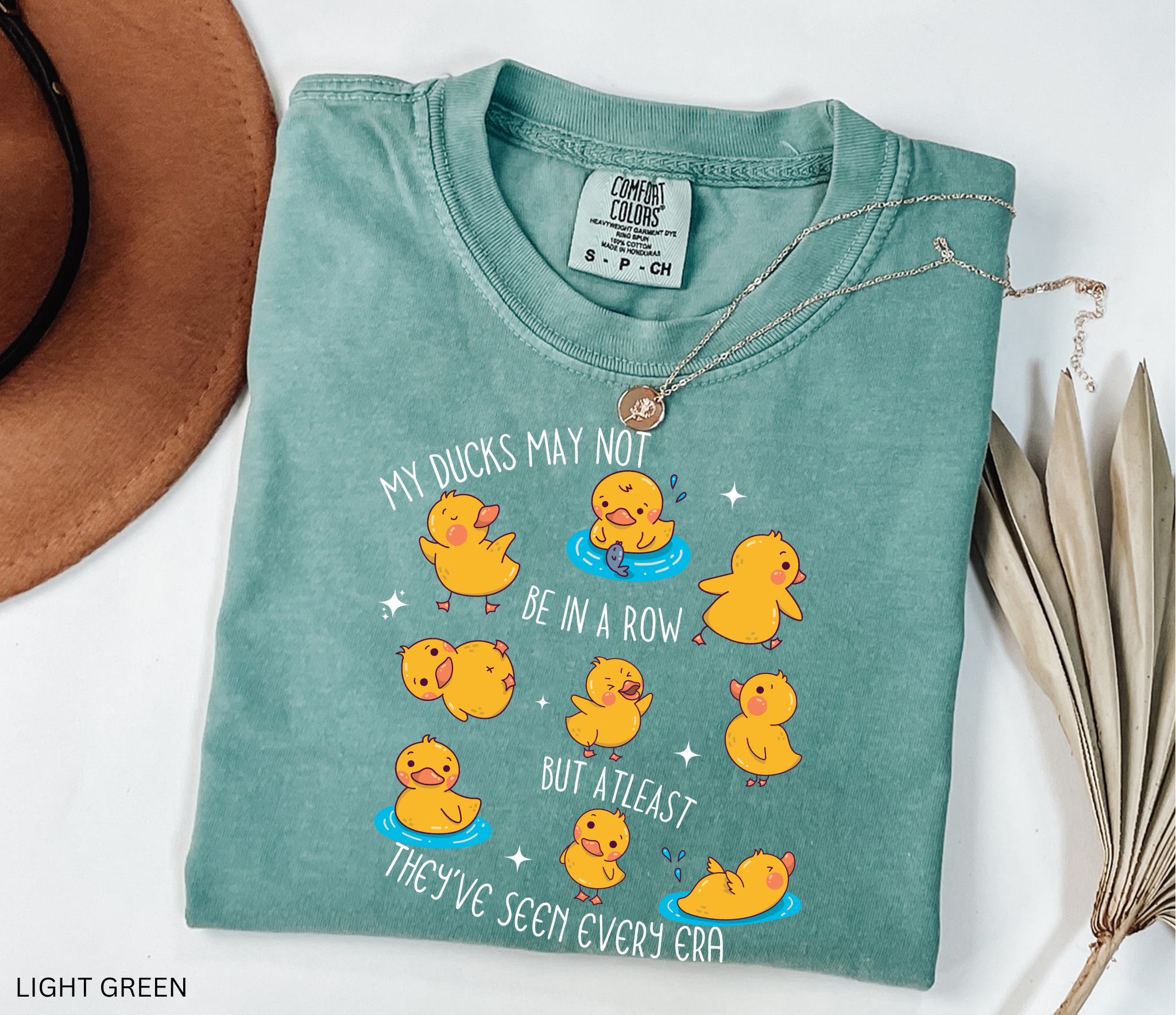 Cute history teacher shirt design with cartoon yellow ducks in different poses and the phrase “My ducks may not be in a row but at least they’ve seen every era.” Funny gift for history and social studies teachers.
