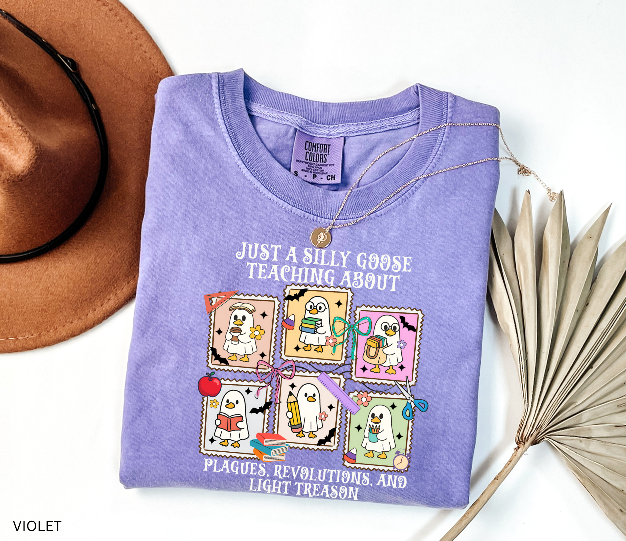 Halloween shirt design with cartoon geese dressed as teachers holding books, pencils, and coffee, surrounded by bats, pumpkins, and school supplies.