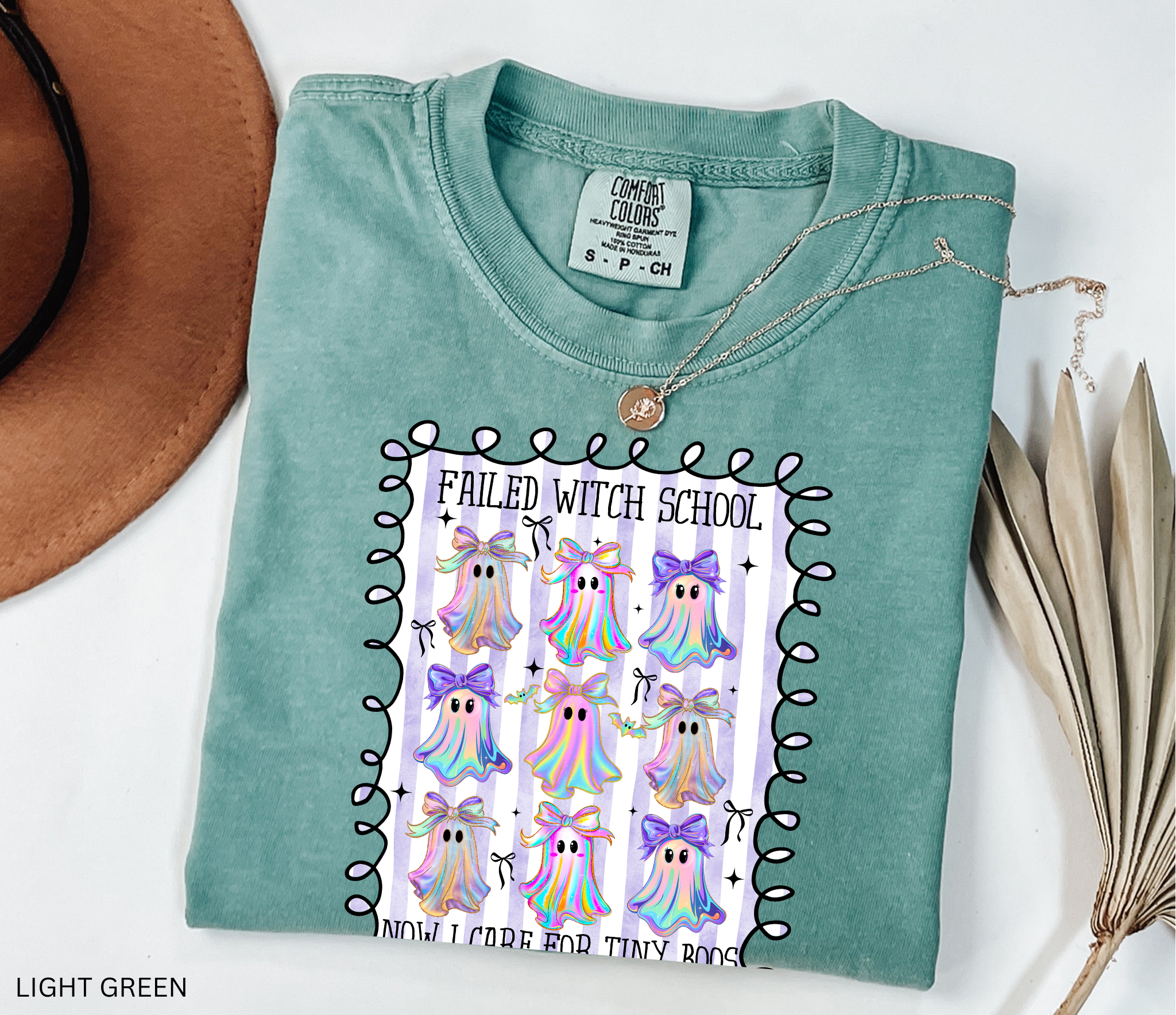 Daycare teacher Halloween shirt with colorful rainbow ghosts and bows, featuring the phrase “Failed Witch School, Now I Care for Tiny Boos.” Funny Halloween tee for childcare workers.