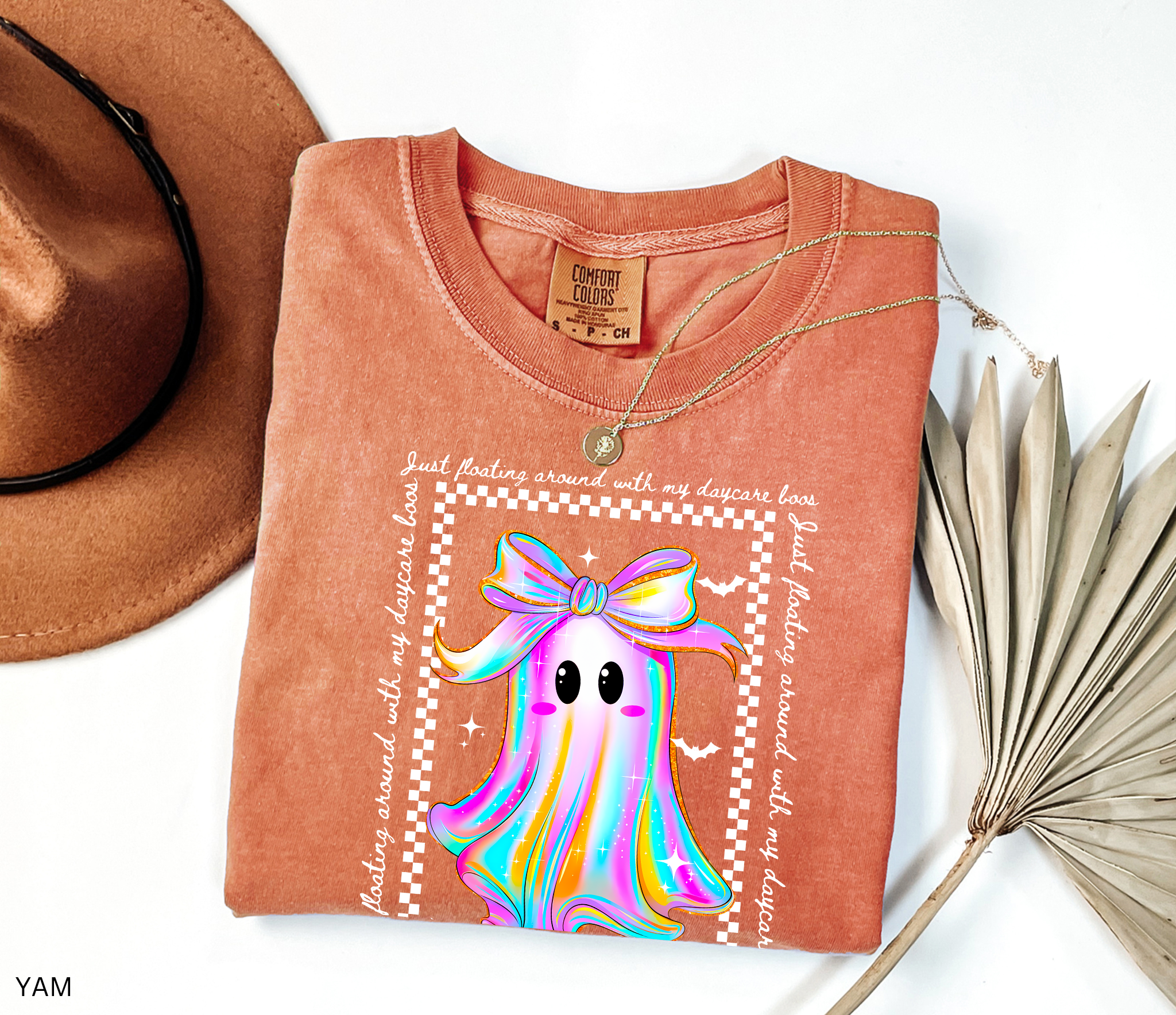 Daycare teacher Halloween shirt with rainbow ghost wearing a big bow, surrounded by stars and bats, with the phrase “Just Floating Around With My Daycare Boos.” Cute spooky season tee for childcare workers.