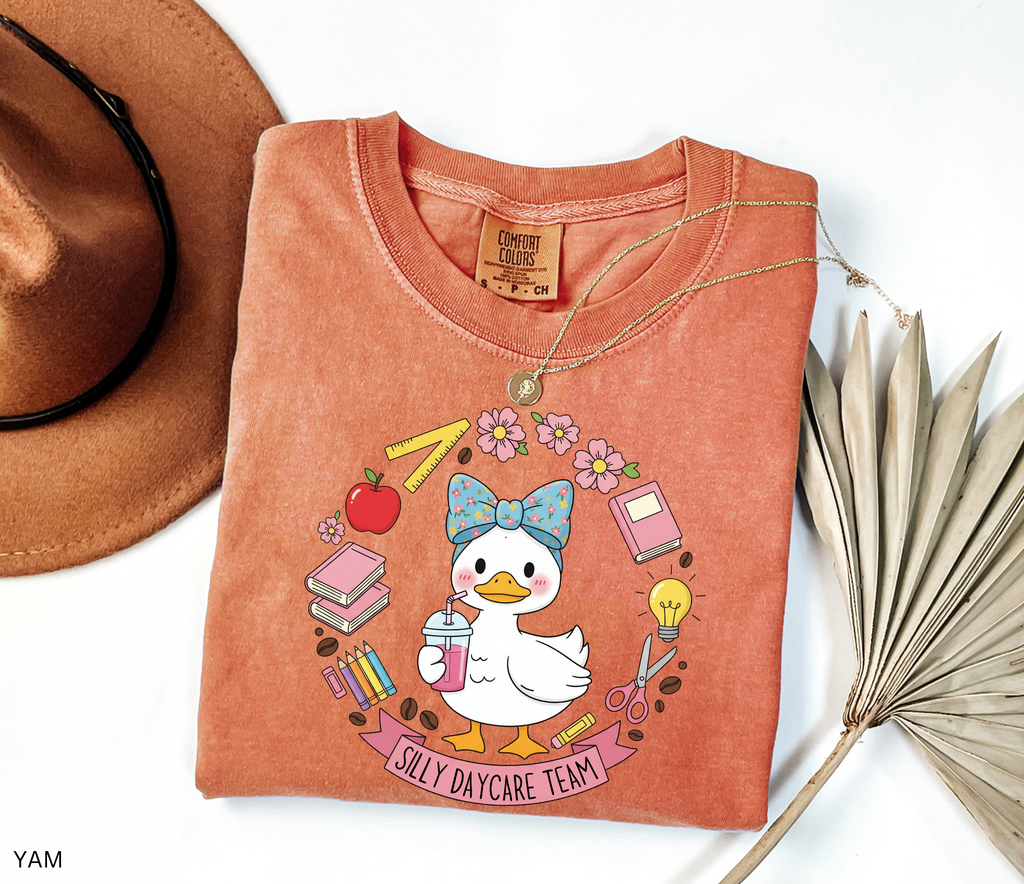 Cute goose in a floral bow holding a drink, surrounded by books, pencils, apple, ruler, flowers, scissors, and lightbulb with banner reading “Silly Daycare Team.”