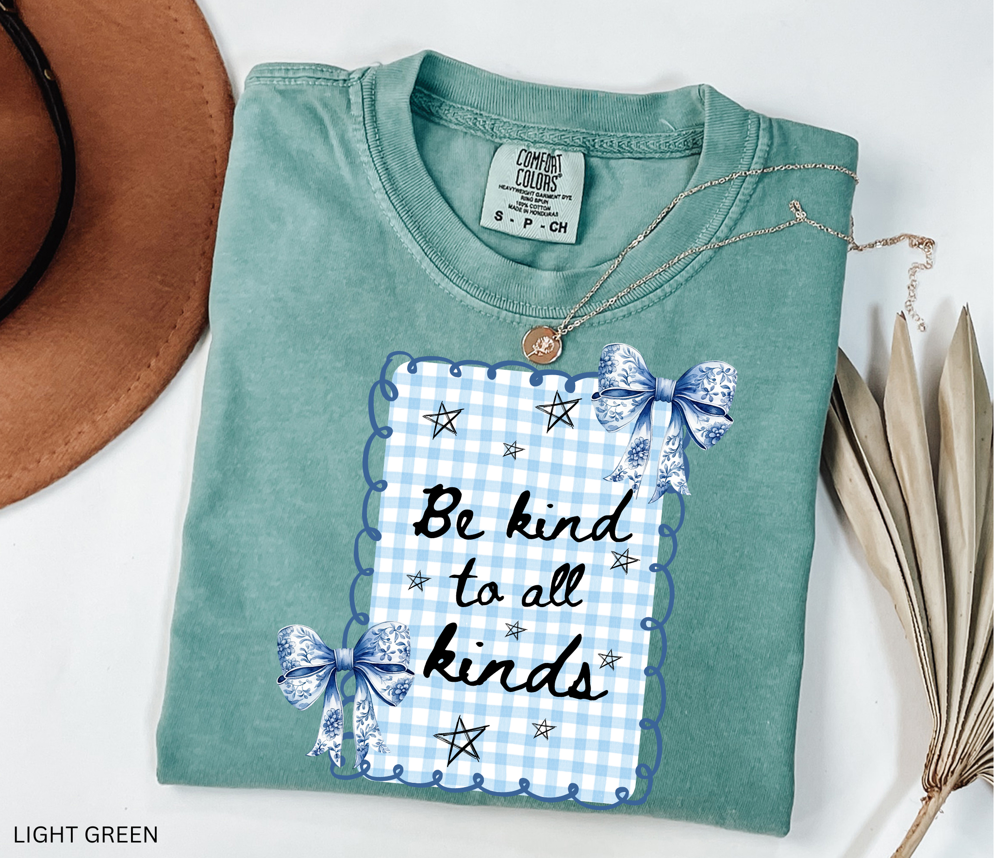 Blue gingham “Be Kind to All Kinds” shirt with bows and stars – kindness graphic tee for teachers and educators.