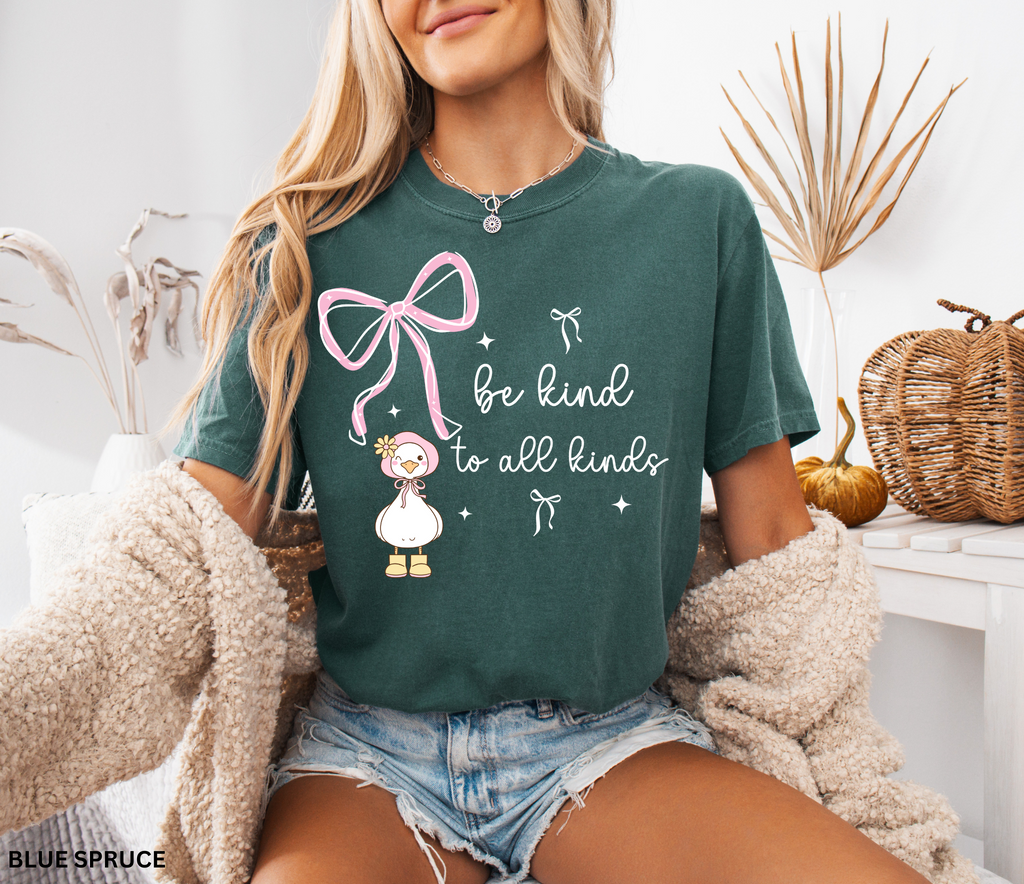 Cute goose wearing a pink bonnet with flower and boots, large pink bow above, and the words “Be Kind to All Kinds.”
