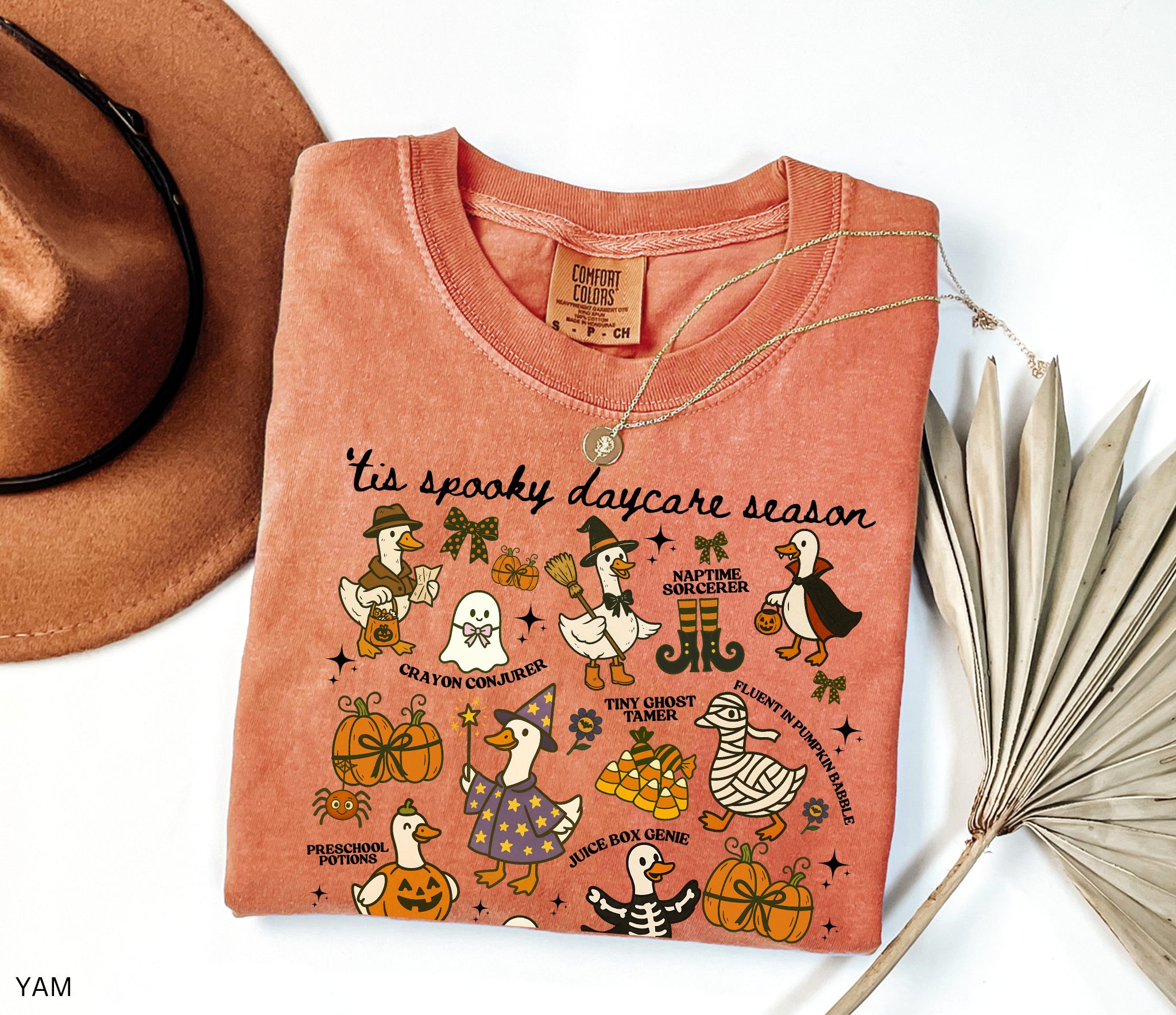 Halloween daycare teacher shirt with geese dressed in spooky costumes and playful phrases like ’Tis Spooky Daycare Season, Crayon Conjurer, and Juice Box Genie.
