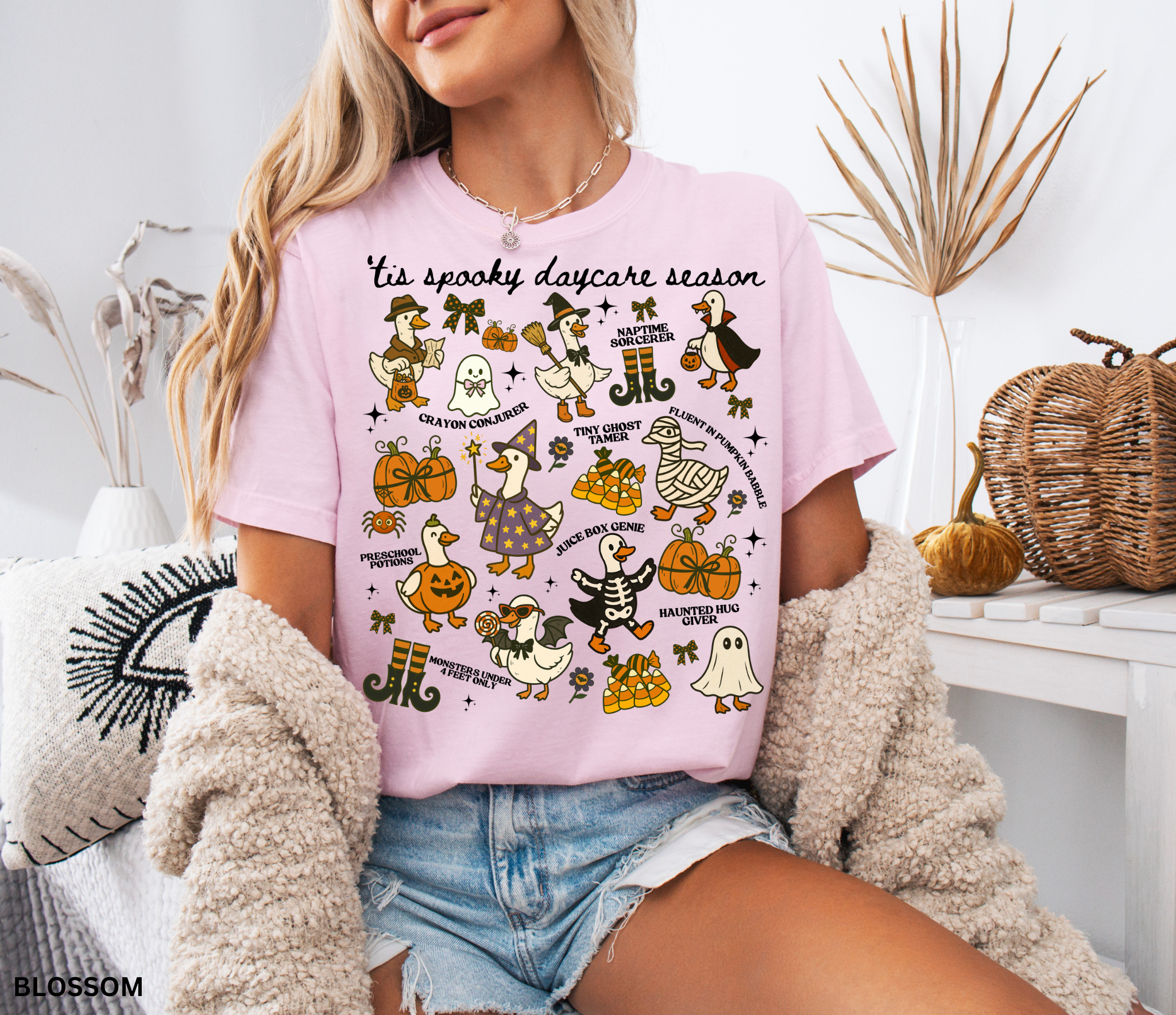 Halloween daycare teacher shirt with geese dressed in spooky costumes and playful phrases like ’Tis Spooky Daycare Season, Crayon Conjurer, and Juice Box Genie.