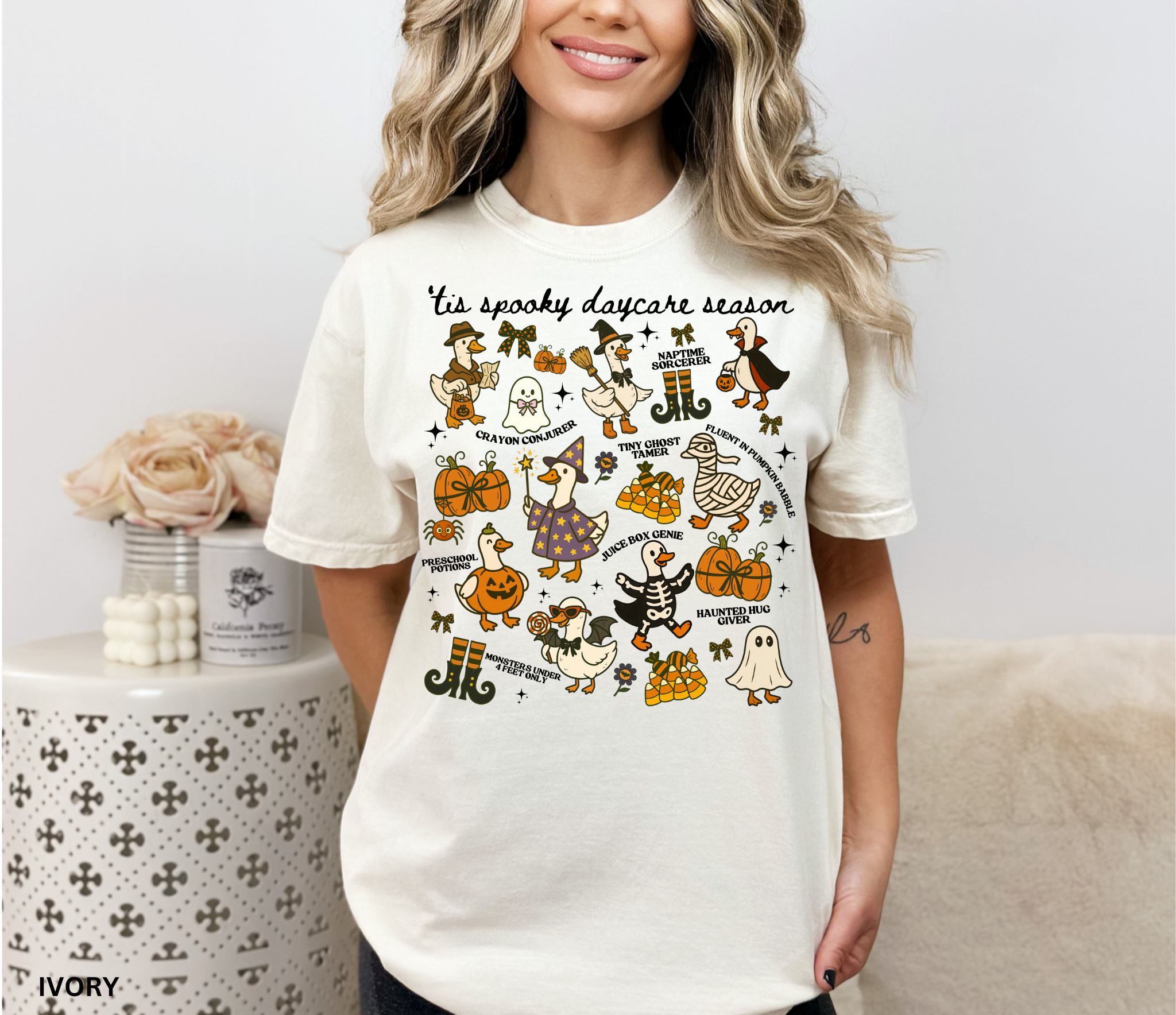 Halloween daycare teacher shirt with geese dressed in spooky costumes and playful phrases like ’Tis Spooky Daycare Season, Crayon Conjurer, and Juice Box Genie.