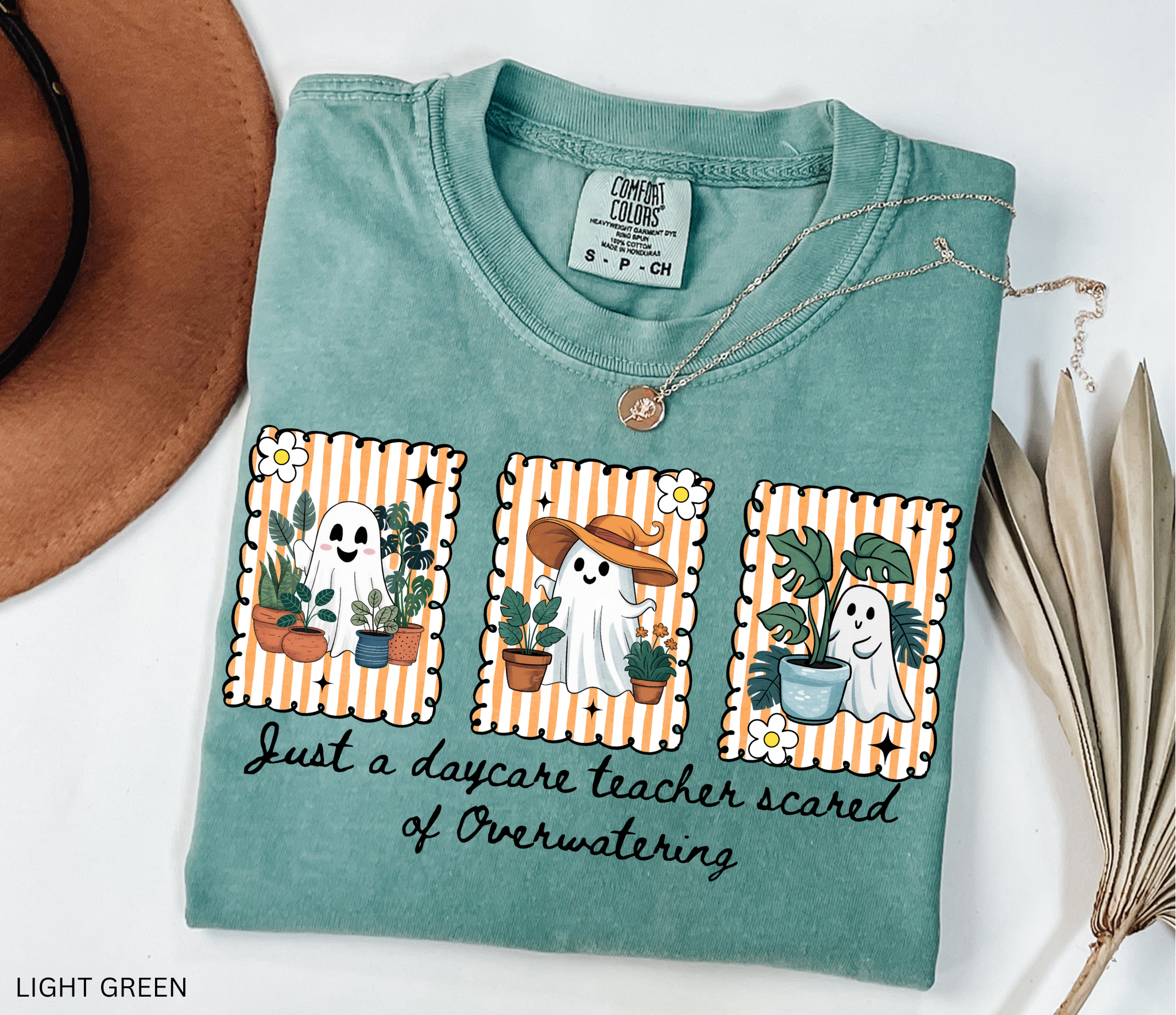 Daycare teacher Halloween shirt with three cute ghosts surrounded by plants and the phrase Just a daycare teacher scared of overwatering.