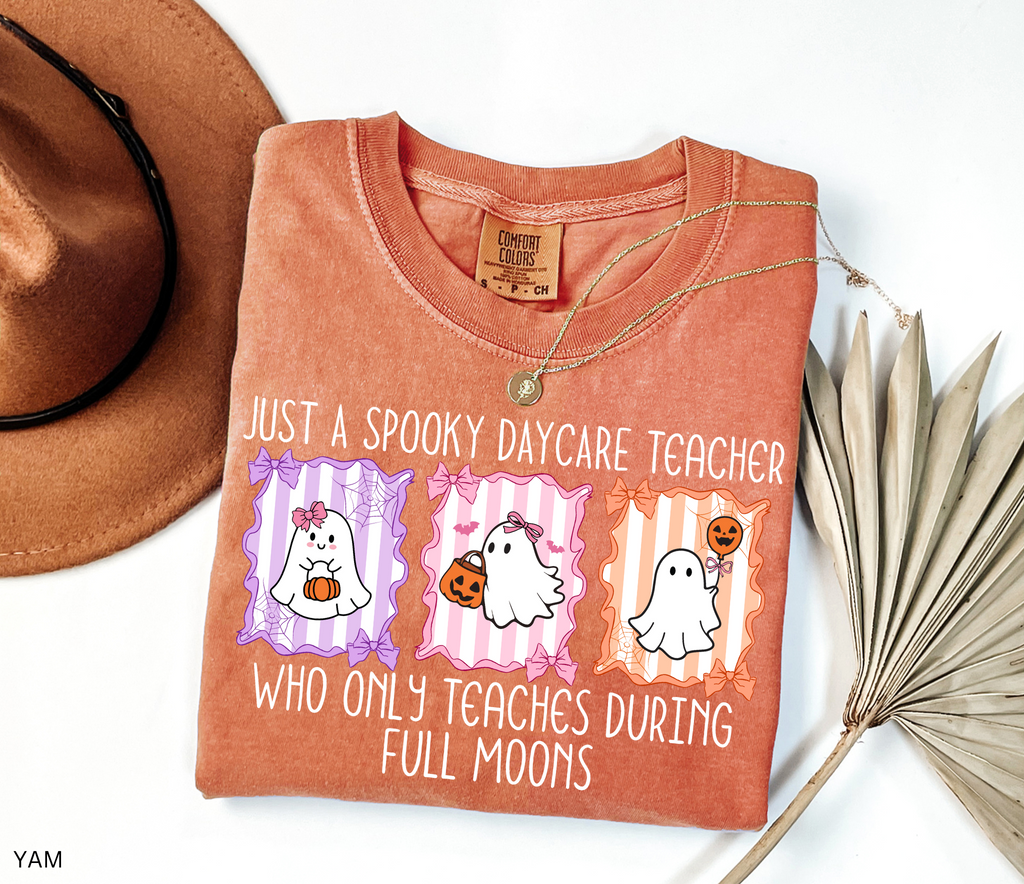 Halloween daycare teacher shirt with three pastel ghosts holding pumpkins, framed with bows and spiderwebs. Text says Just a spooky daycare teacher who only teaches during full moons.