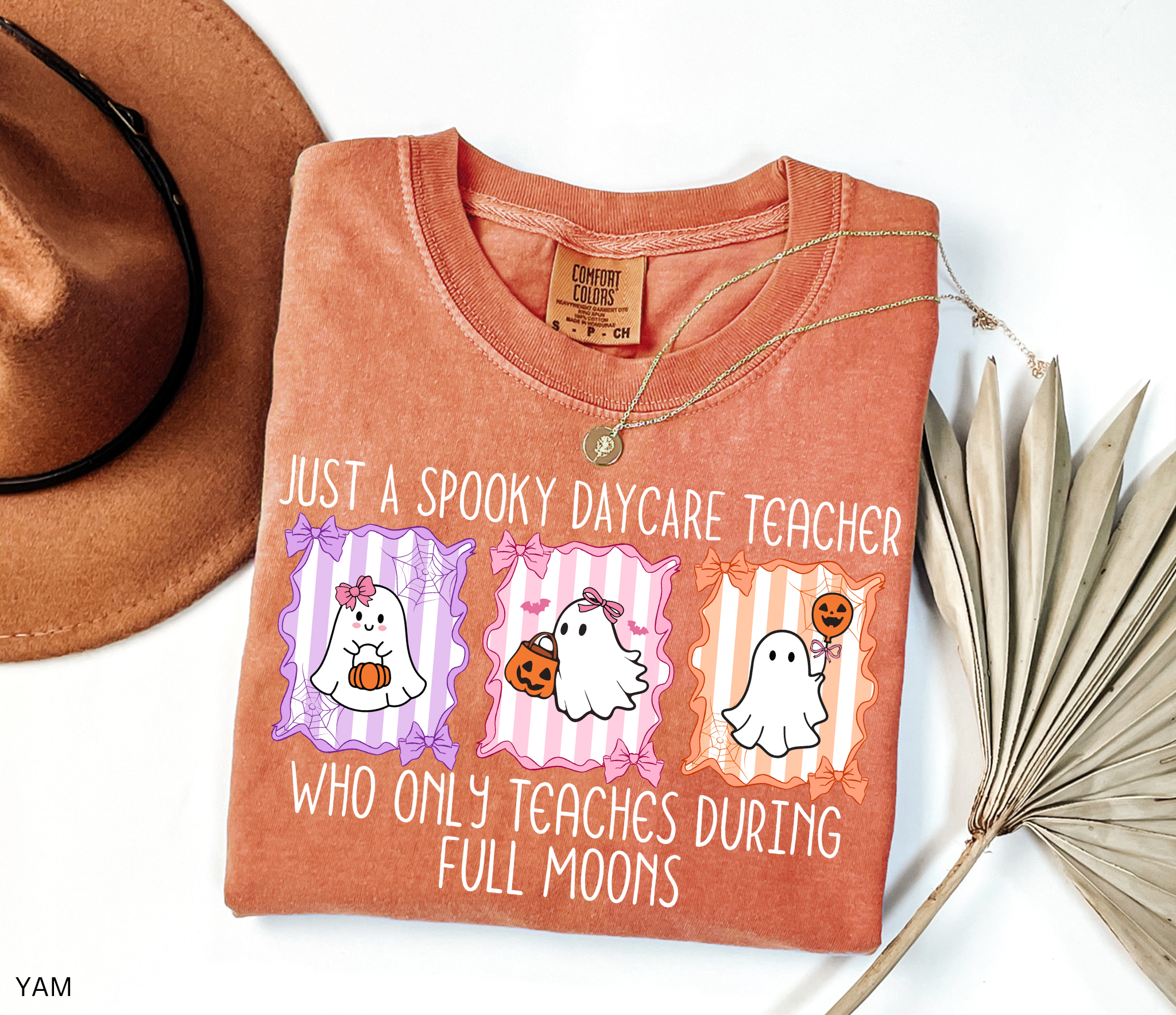 Halloween daycare teacher shirt with three pastel ghosts holding pumpkins, framed with bows and spiderwebs. Text says Just a spooky daycare teacher who only teaches during full moons.