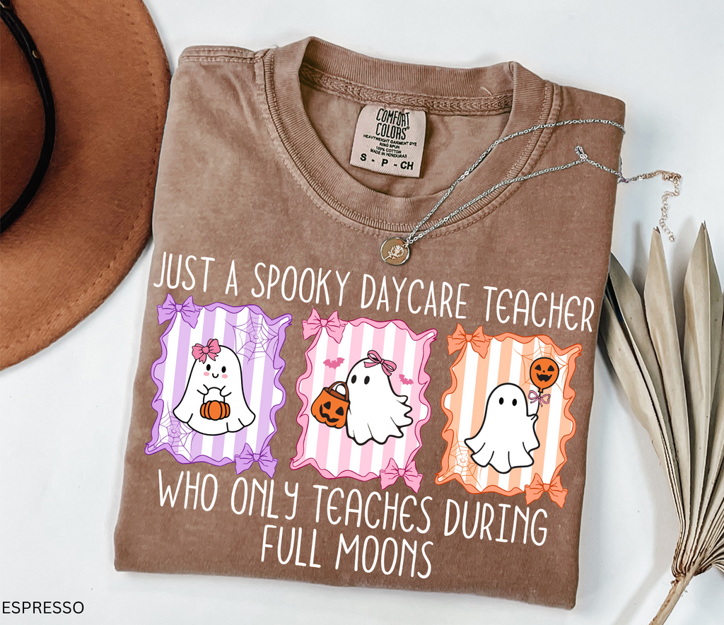 Halloween daycare teacher shirt with three pastel ghosts holding pumpkins, framed with bows and spiderwebs. Text says Just a spooky daycare teacher who only teaches during full moons.