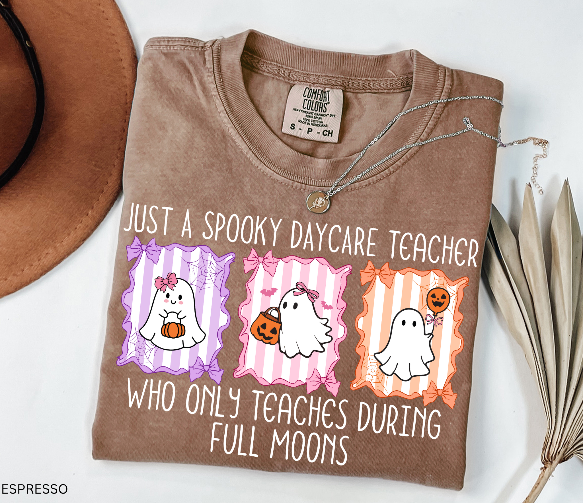 Halloween daycare teacher shirt with three pastel ghosts holding pumpkins, framed with bows and spiderwebs. Text says Just a spooky daycare teacher who only teaches during full moons.