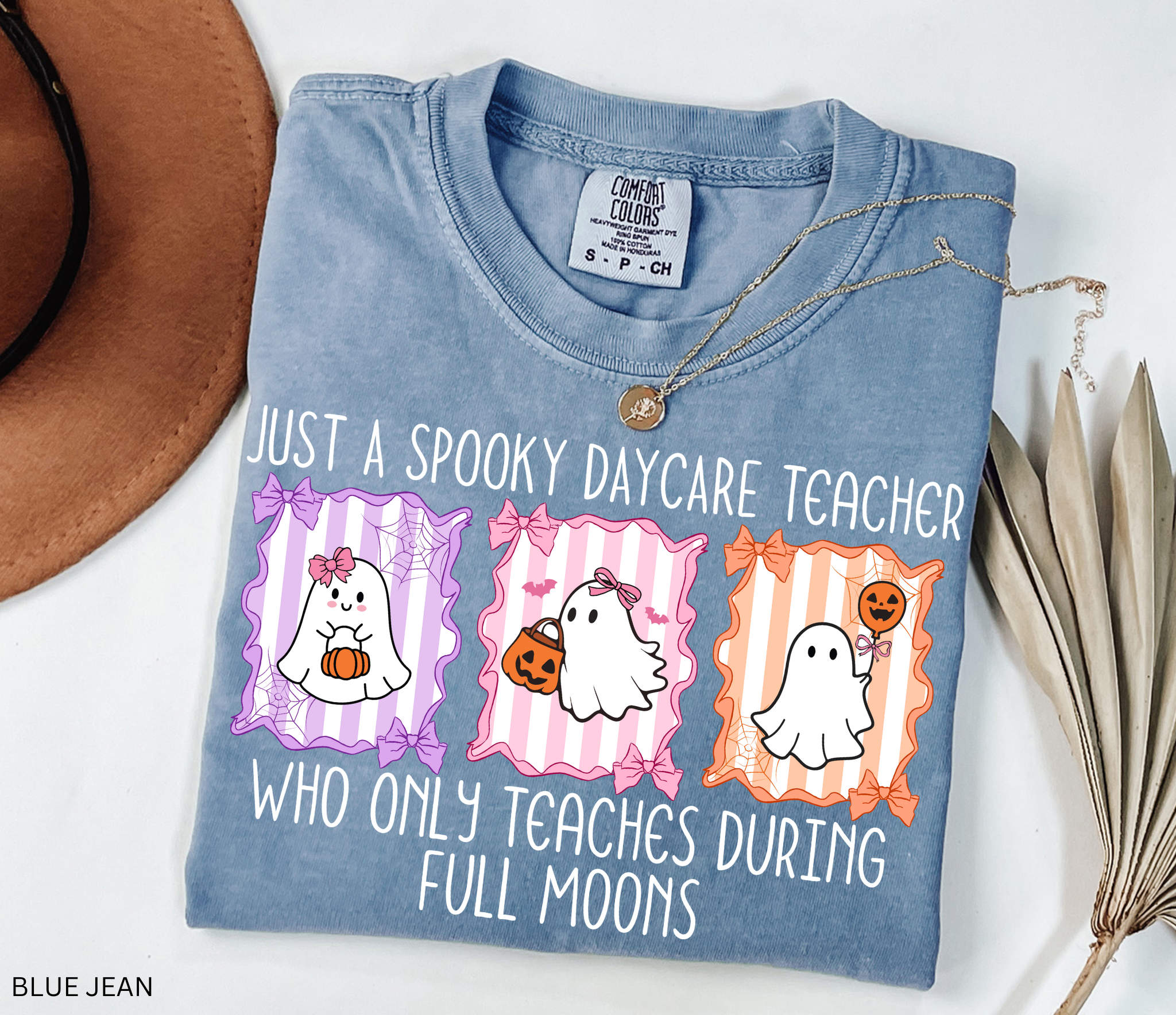 Halloween daycare teacher shirt with three pastel ghosts holding pumpkins, framed with bows and spiderwebs. Text says Just a spooky daycare teacher who only teaches during full moons.