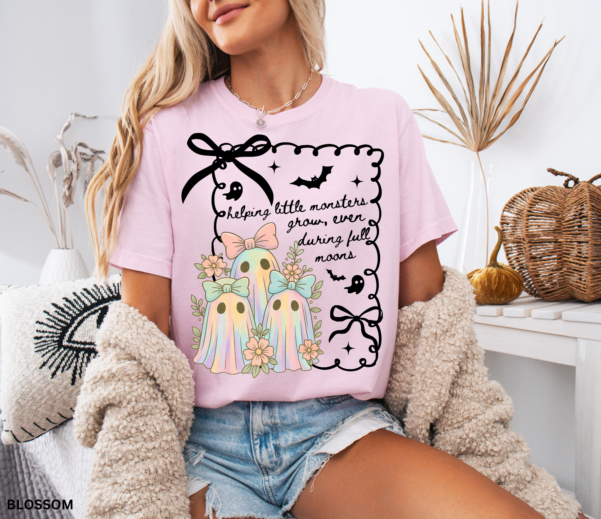 Daycare teacher Halloween shirt with three pastel rainbow ghosts wearing bows, surrounded by flowers, in a spooky-cute design.
