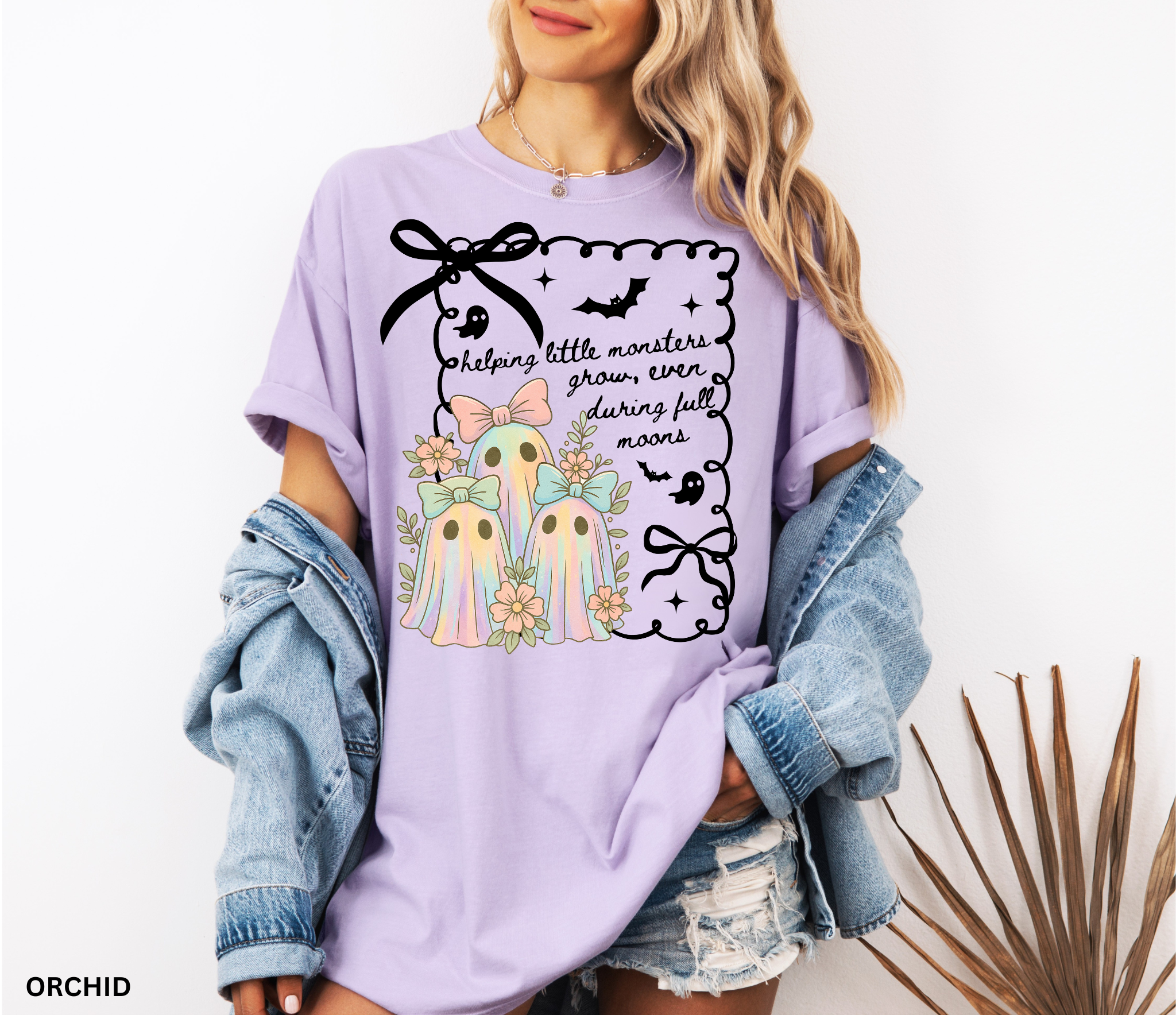 Daycare teacher Halloween shirt with three pastel rainbow ghosts wearing bows, surrounded by flowers, in a spooky-cute design.