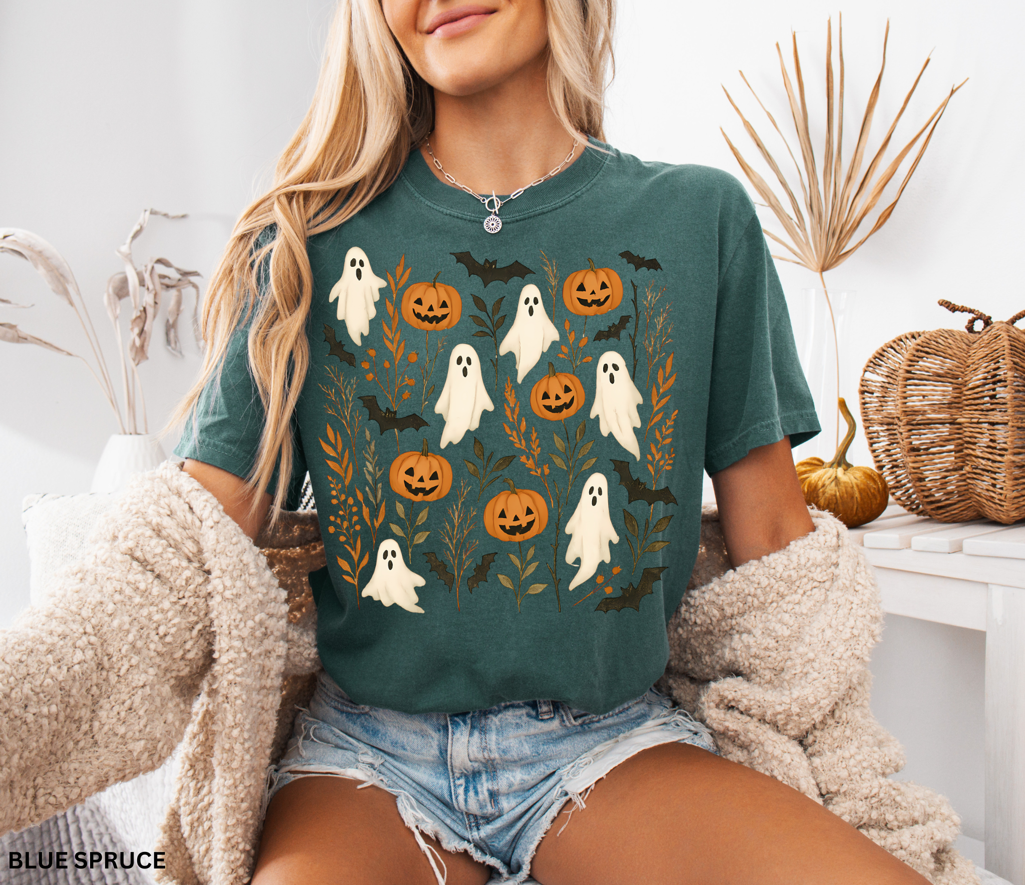 Halloween shirt featuring floating white ghosts, carved pumpkins, bats, and autumn leaves in a whimsical cottagecore design.