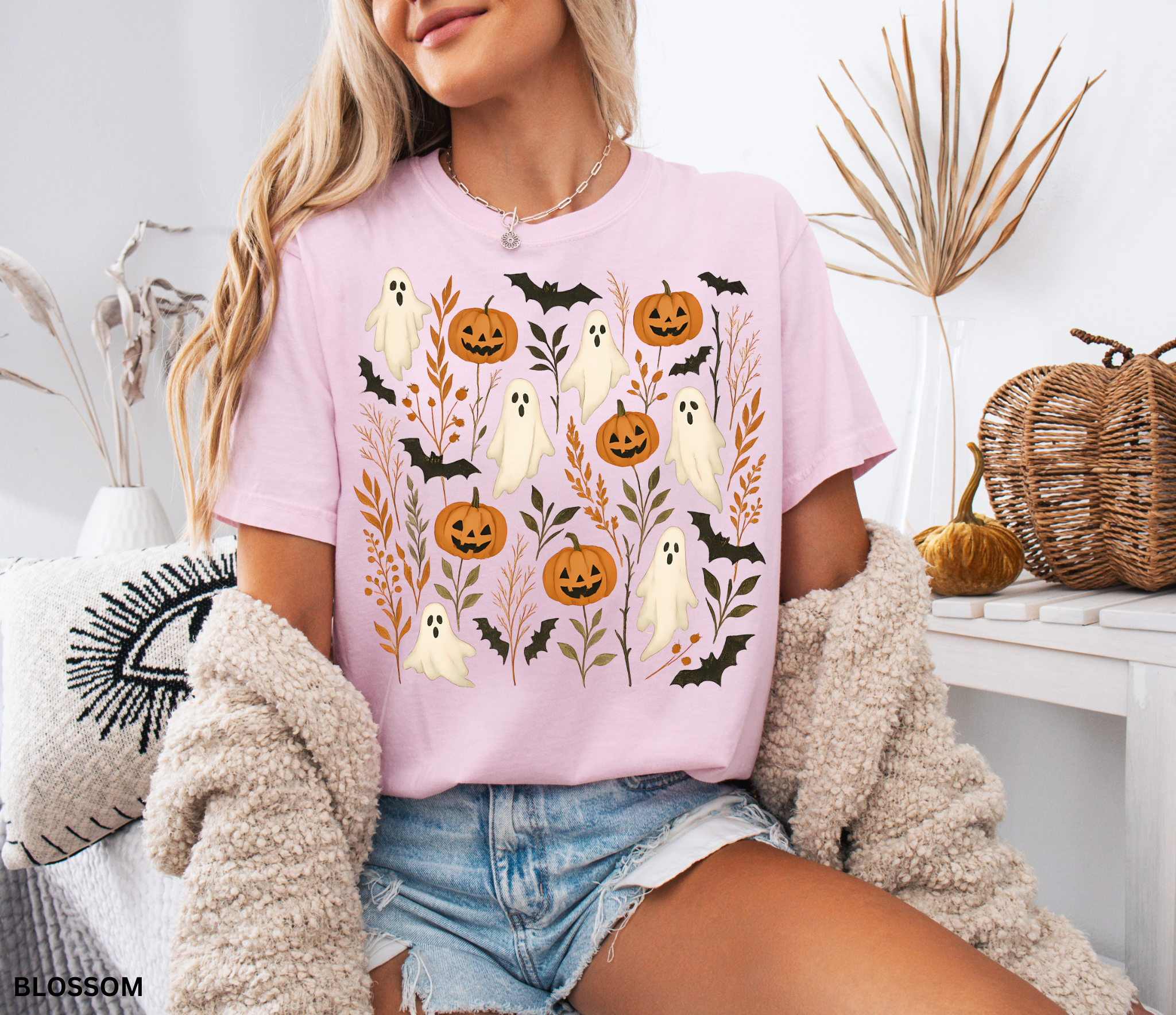 Halloween shirt featuring floating white ghosts, carved pumpkins, bats, and autumn leaves in a whimsical cottagecore design.