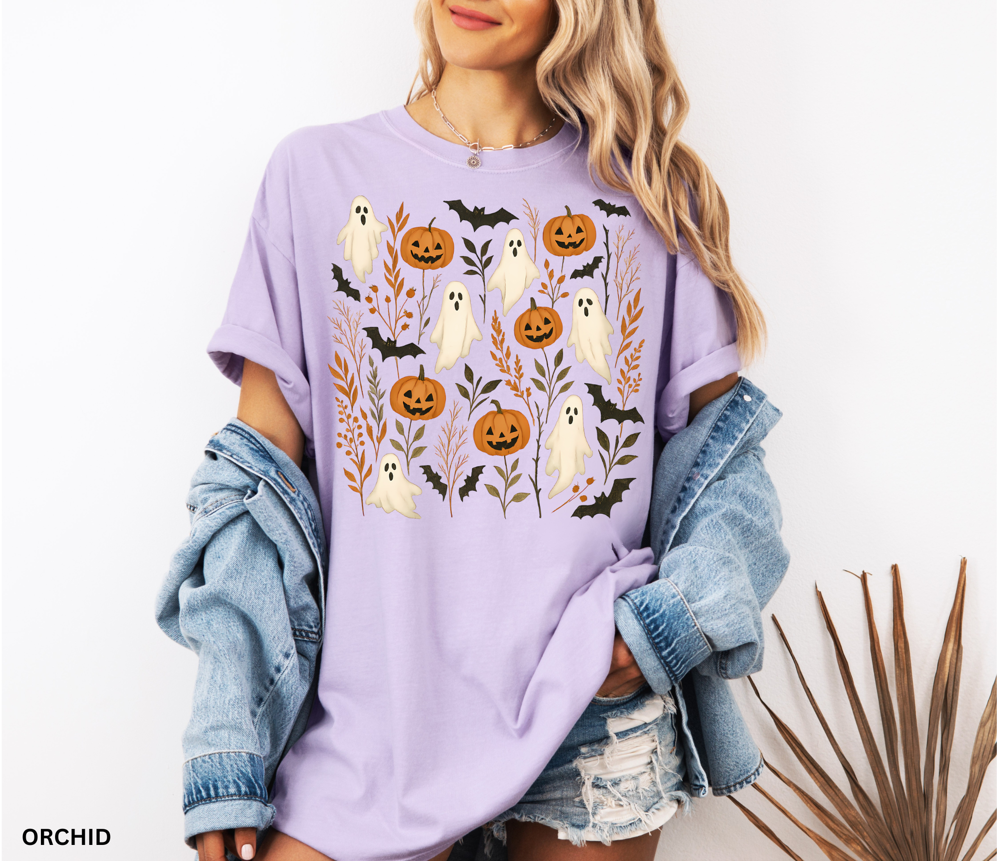 Halloween shirt featuring floating white ghosts, carved pumpkins, bats, and autumn leaves in a whimsical cottagecore design.