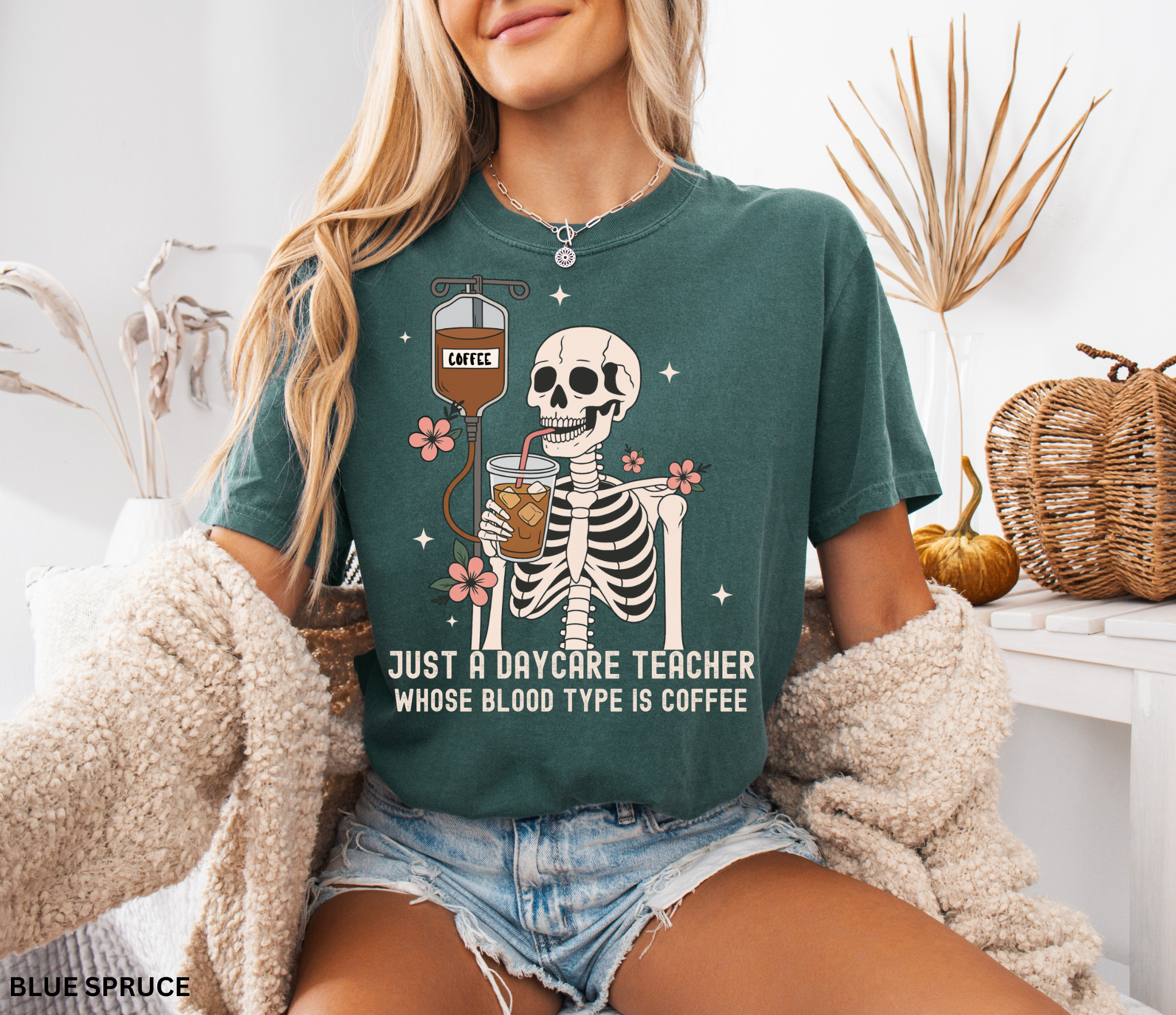 Daycare teacher Halloween shirt with a skeleton sipping iced coffee through a straw connected to an IV bag labeled “coffee,” surrounded by flowers and stars.