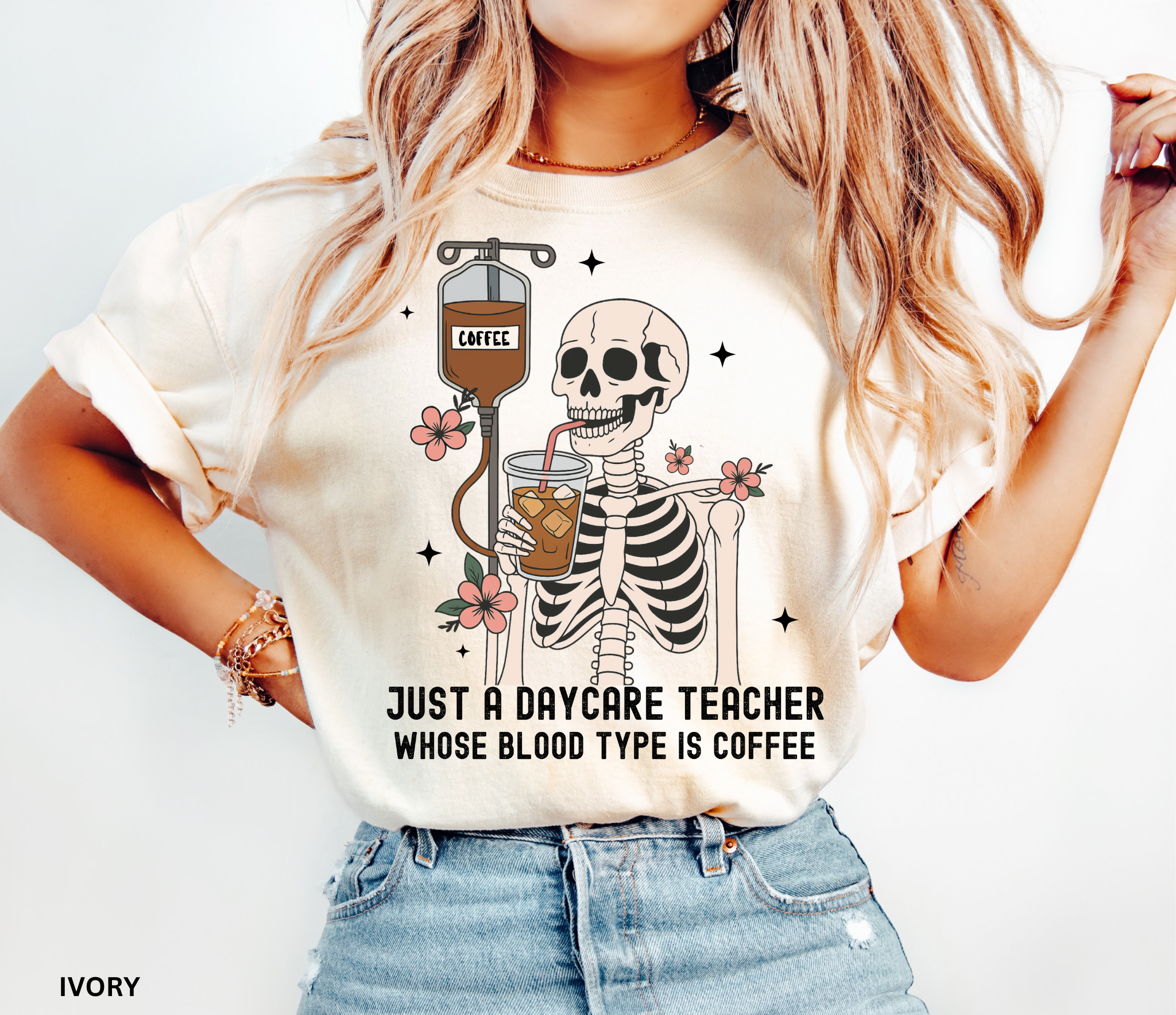 Daycare teacher Halloween shirt with a skeleton sipping iced coffee through a straw connected to an IV bag labeled “coffee,” surrounded by flowers and stars.