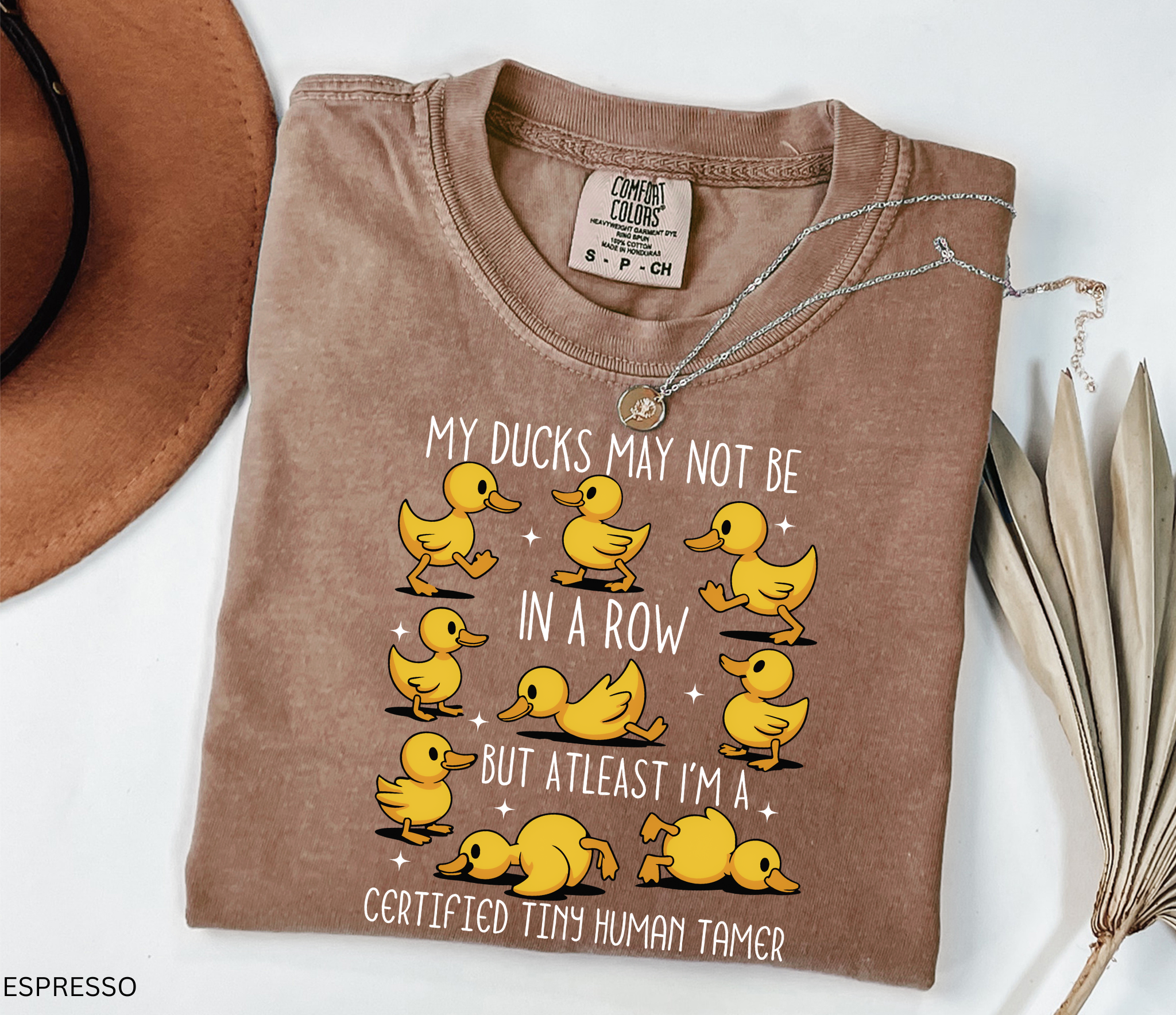 Daycare teacher shirt with nine playful cartoon yellow ducks in different silly poses, representing humor and the chaos of preschool teaching.