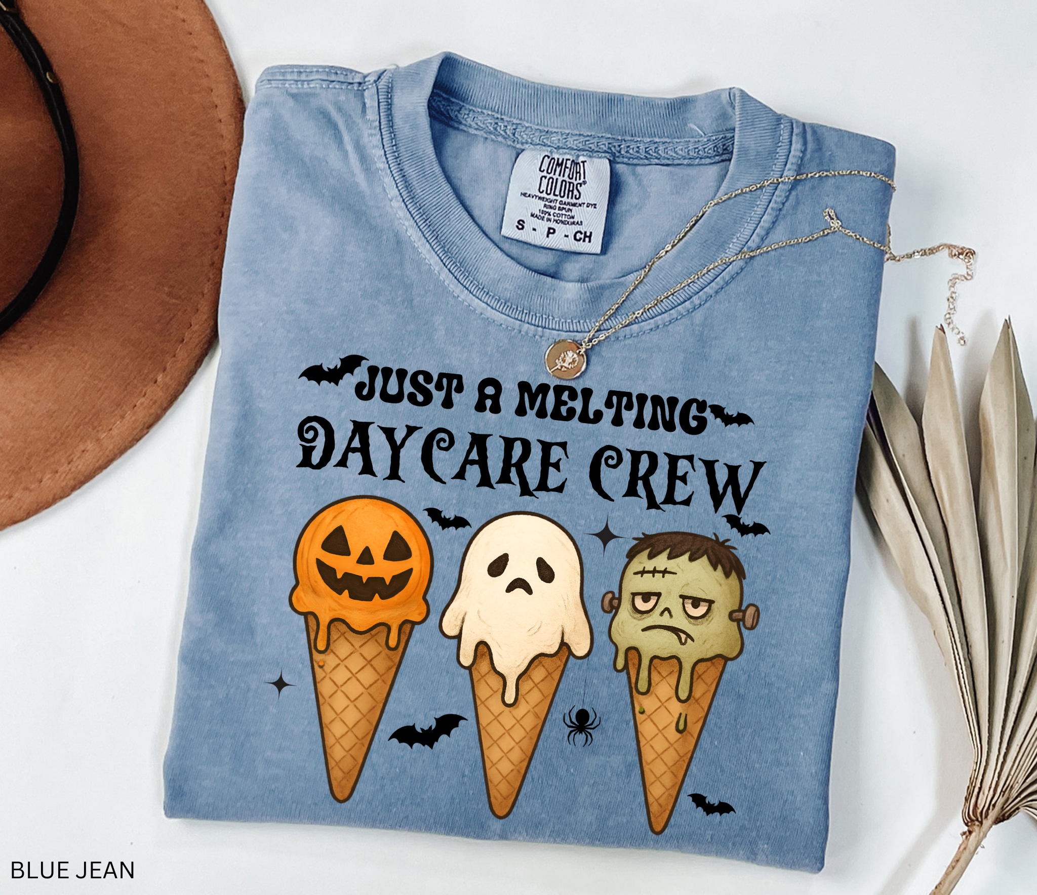 Daycare teacher Halloween shirt with three ice cream cones designed as a pumpkin, ghost, and Frankenstein monster, with the phrase “Just a Melting Daycare Crew.”