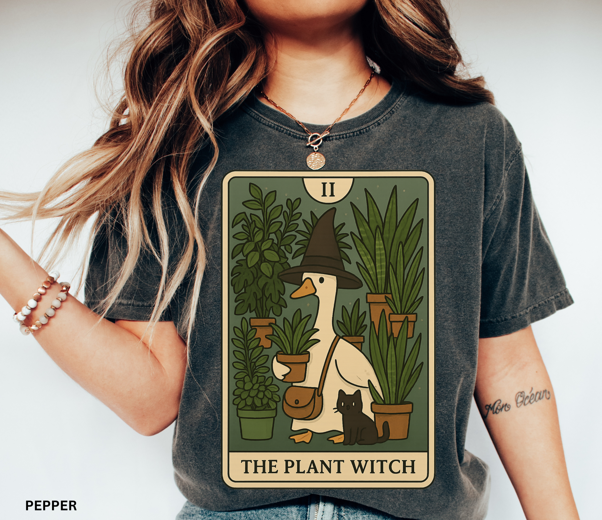 Cartoon goose in a witch hat holding plants with black cat – tarot-style Plant Witch shirt design
