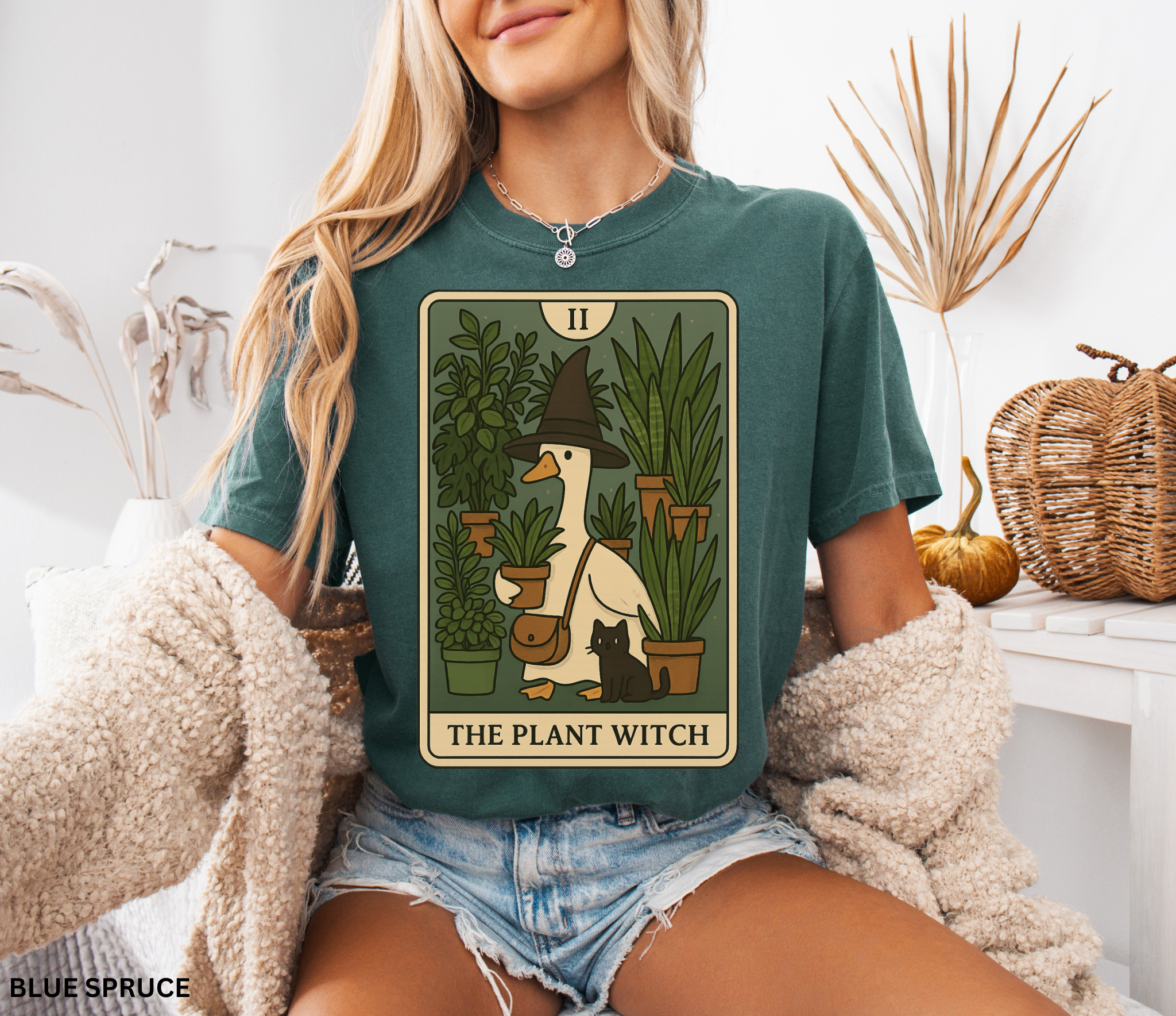 Cartoon goose in a witch hat holding plants with black cat – tarot-style Plant Witch shirt design