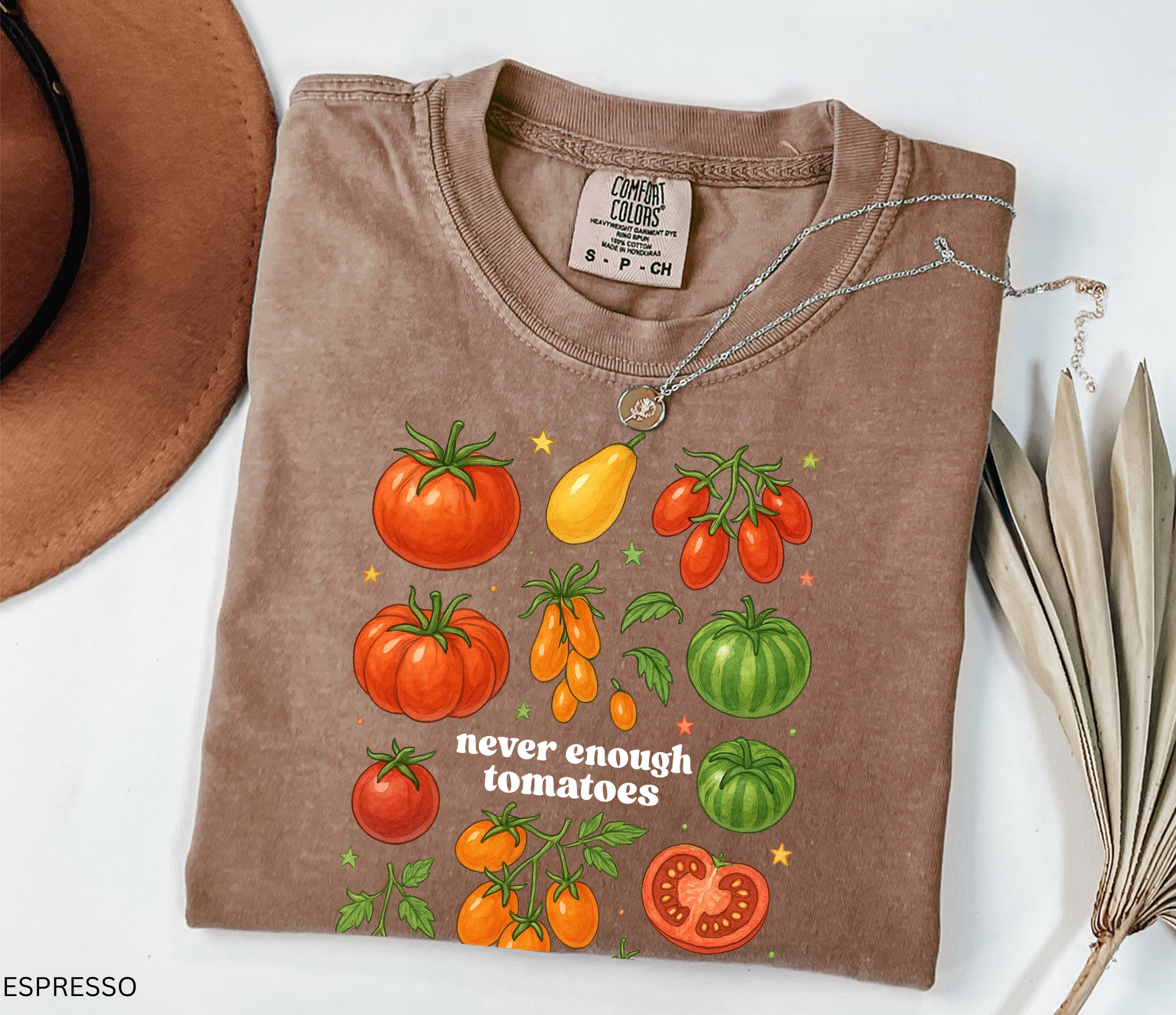Watercolor-style illustration of different tomato varieties with the phrase “never enough tomatoes” on a cottagecore garden t-shirt.