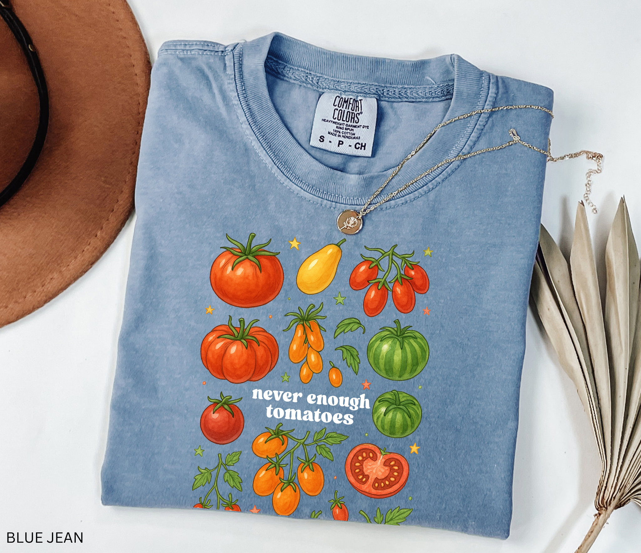 Watercolor-style illustration of different tomato varieties with the phrase “never enough tomatoes” on a cottagecore garden t-shirt.