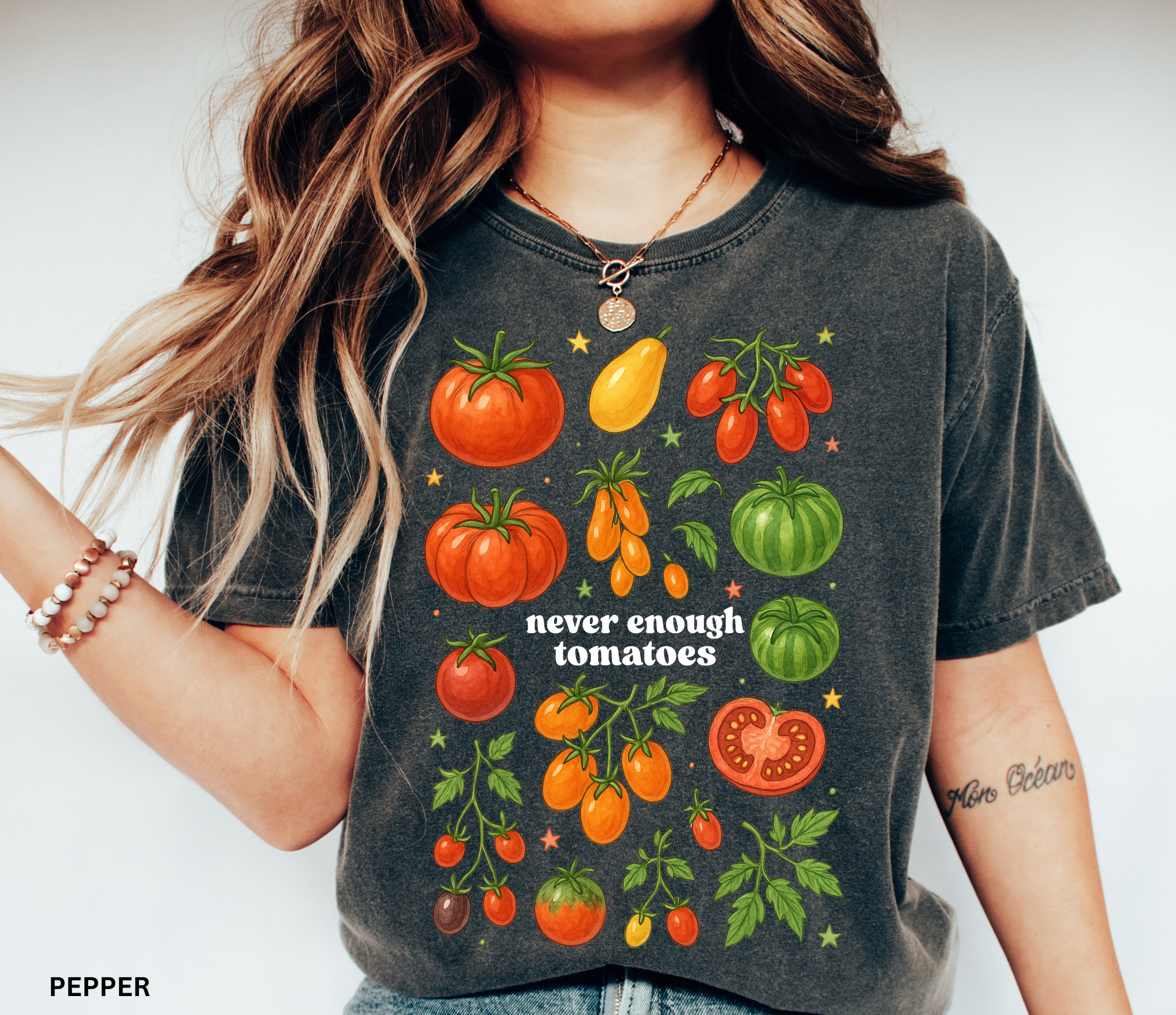 Watercolor-style illustration of different tomato varieties with the phrase “never enough tomatoes” on a cottagecore garden t-shirt.