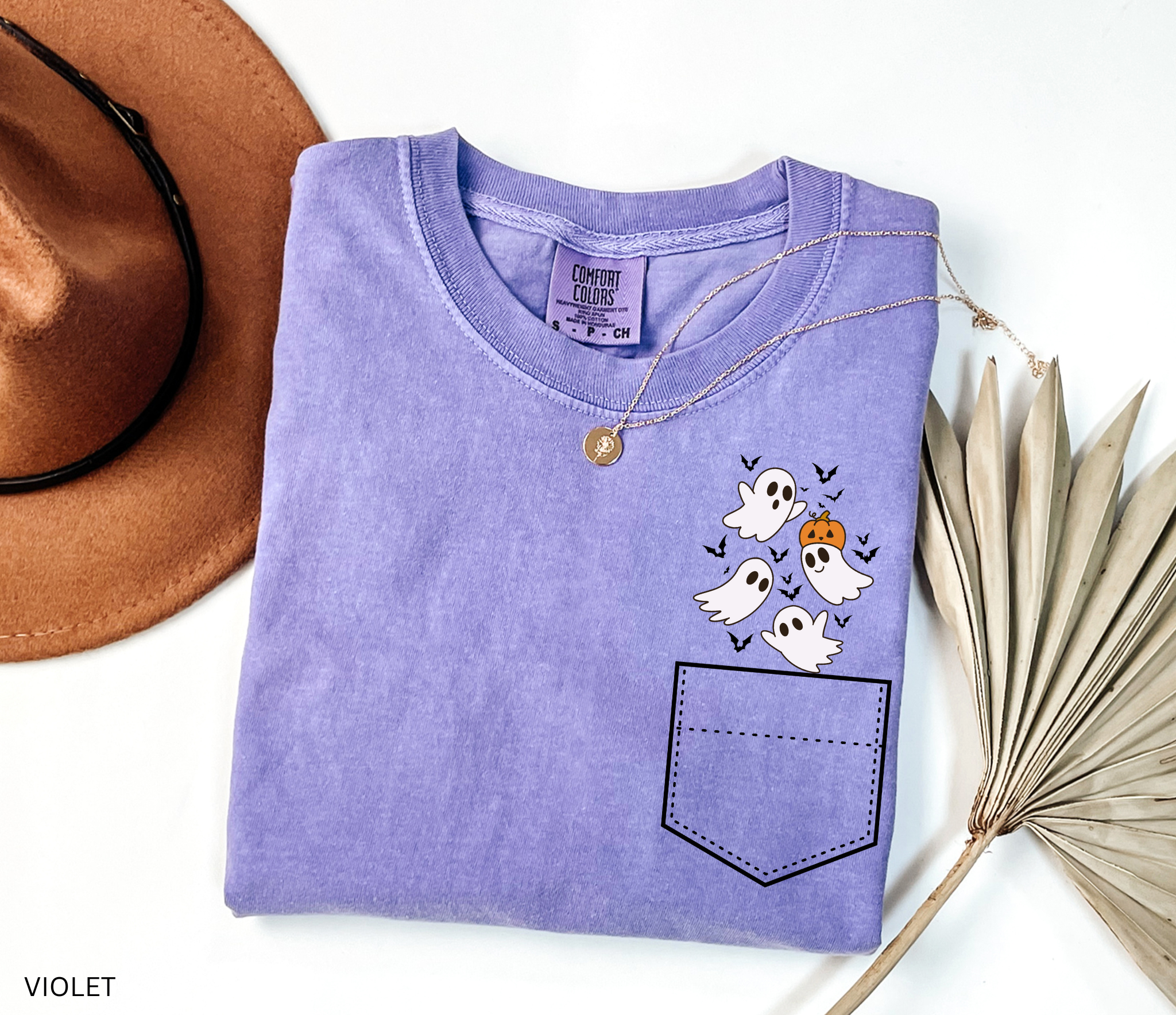 Halloween pocket shirt design with a group of smiling ghosts, a pumpkin, and bats peeking from the top corner.