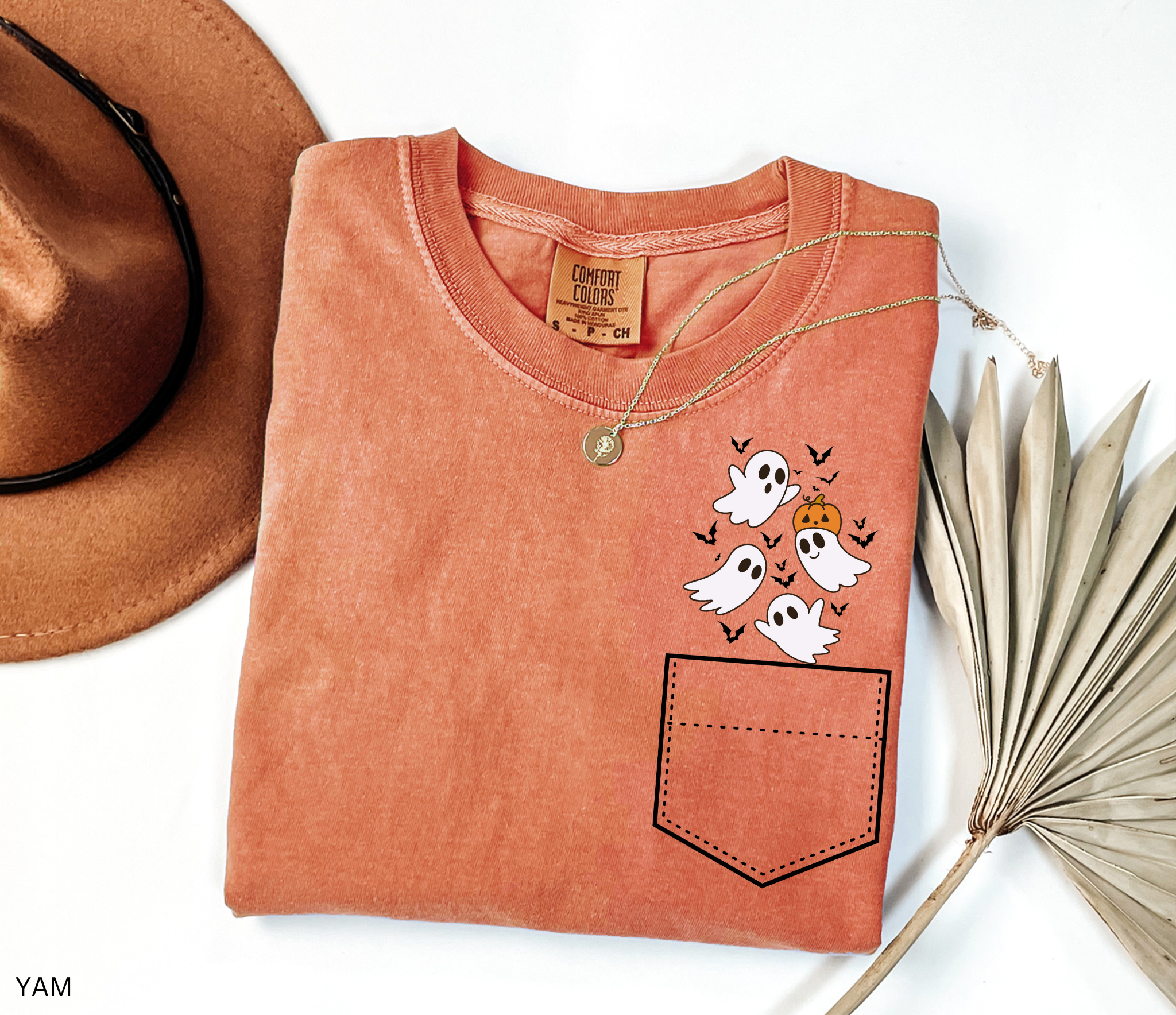Halloween pocket shirt design with a group of smiling ghosts, a pumpkin, and bats peeking from the top corner.