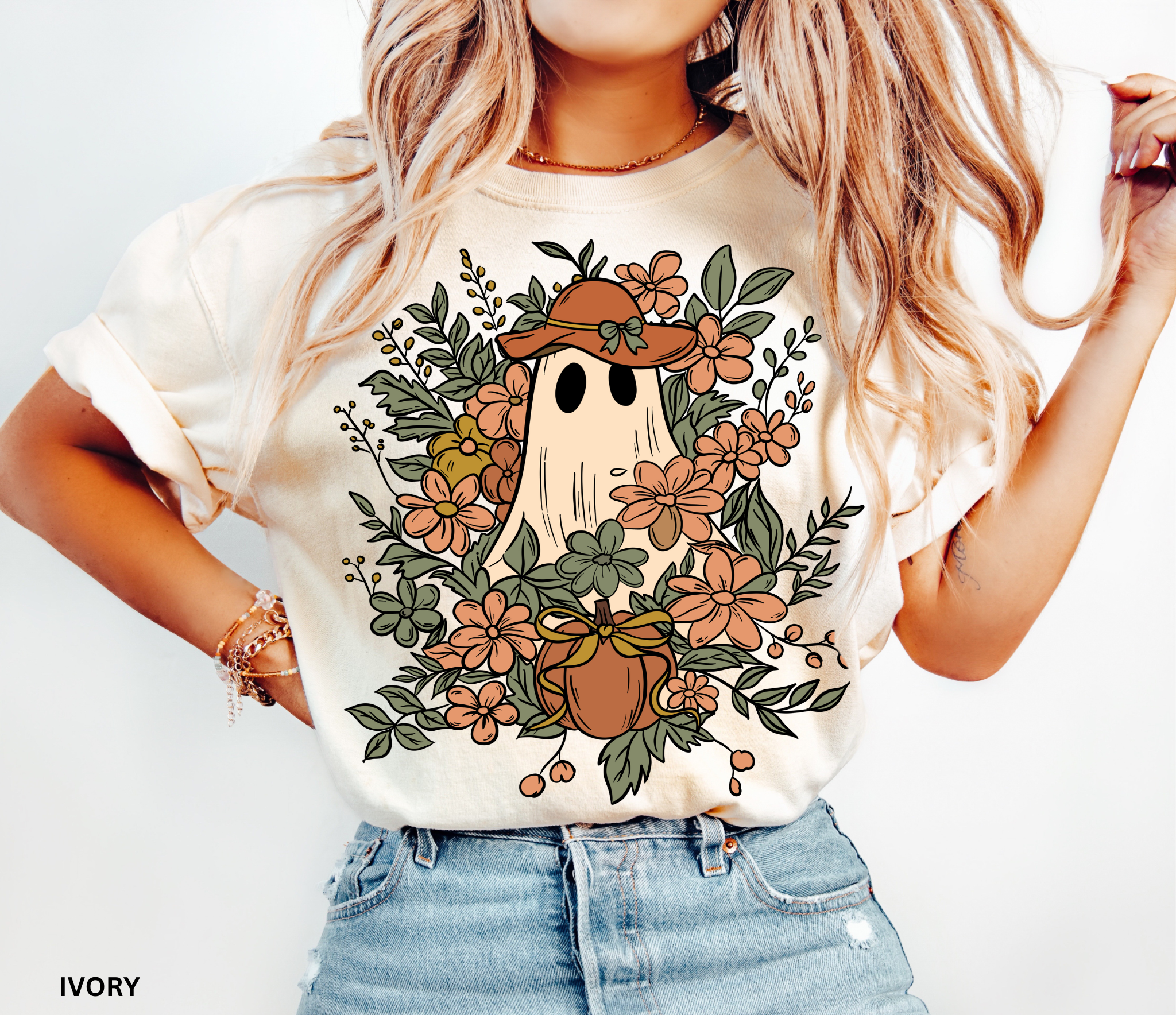 Halloween shirt featuring a ghost in a wide-brimmed hat surrounded by orange flowers, greenery, and a pumpkin with a bow – a spooky cottagecore gardening design.