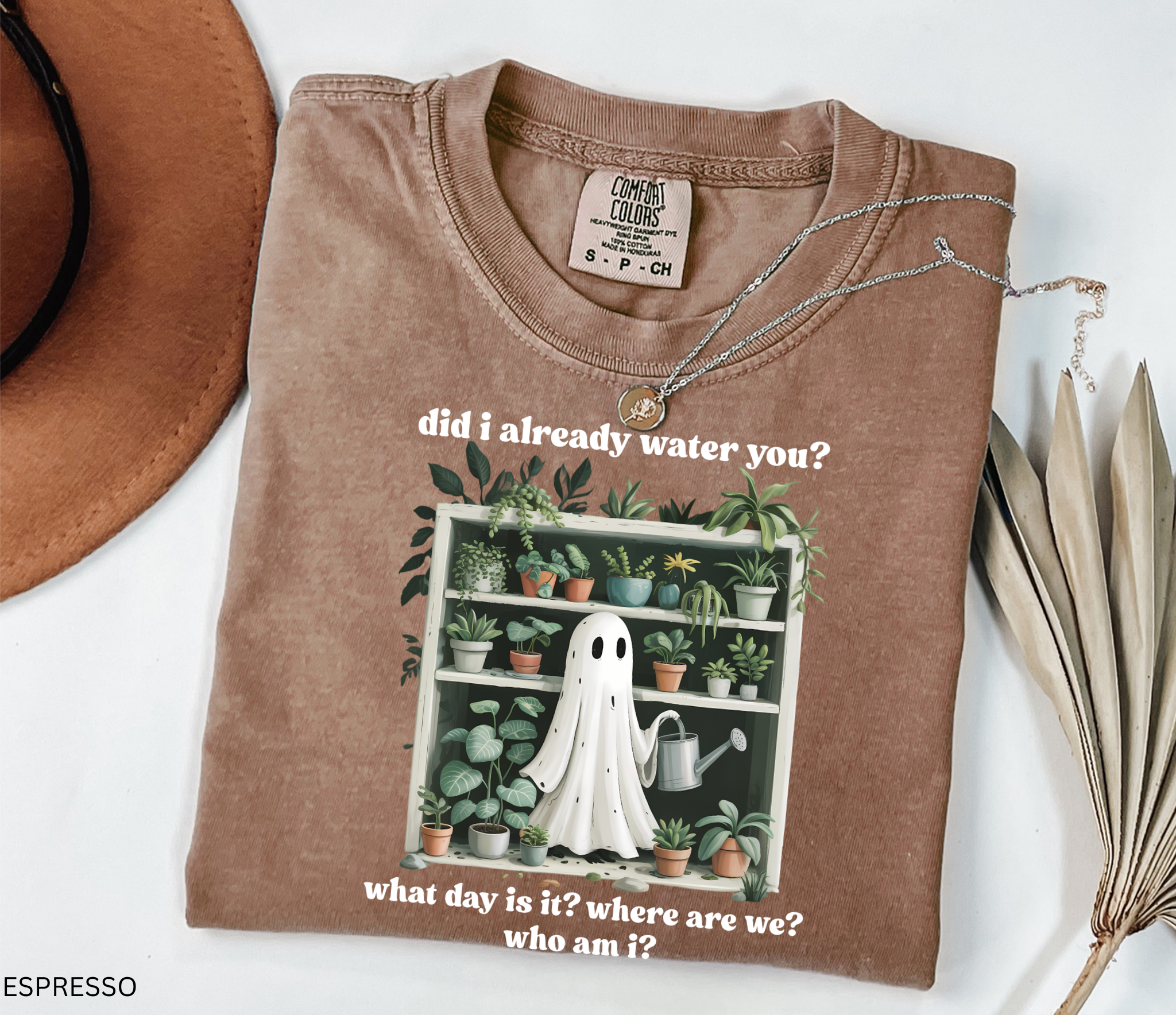 Funny gardening shirt featuring a ghost holding a watering can in front of a shelf full of houseplants with the phrase “Did I already water you? What day is it? Where are we? Who am I?”