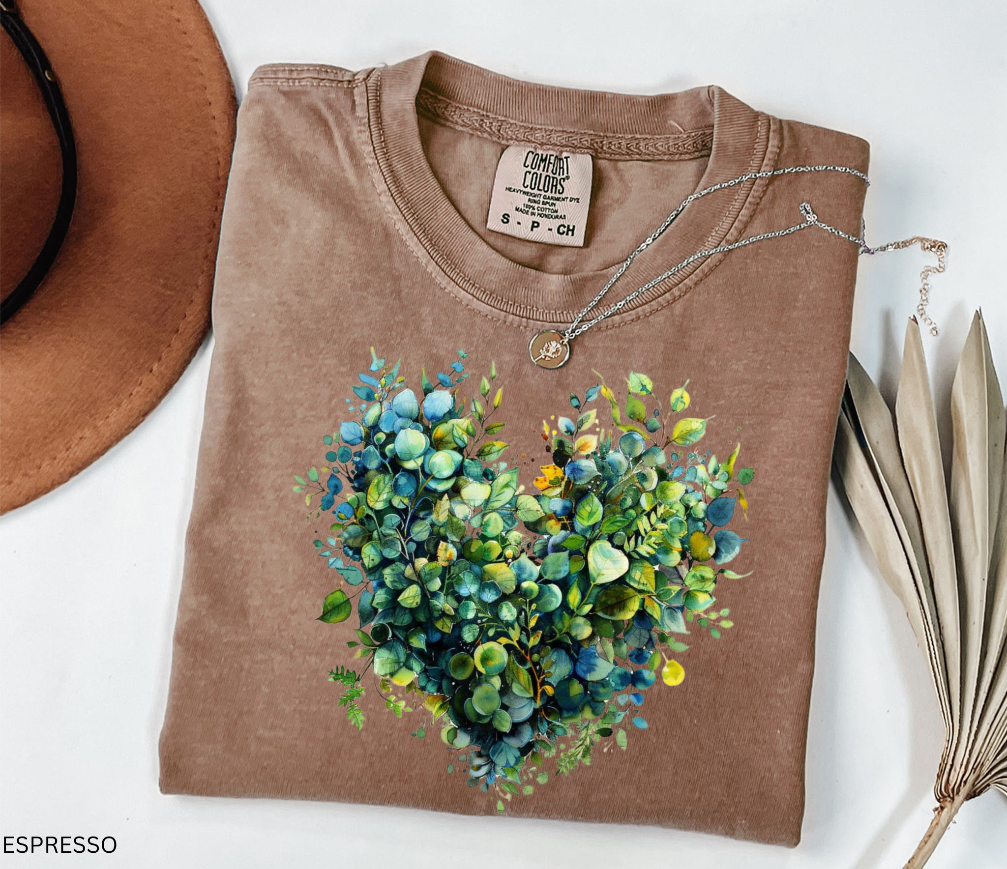 Watercolor-style greenery arranged in the shape of a heart, printed as a botanical design on a cottagecore t-shirt.