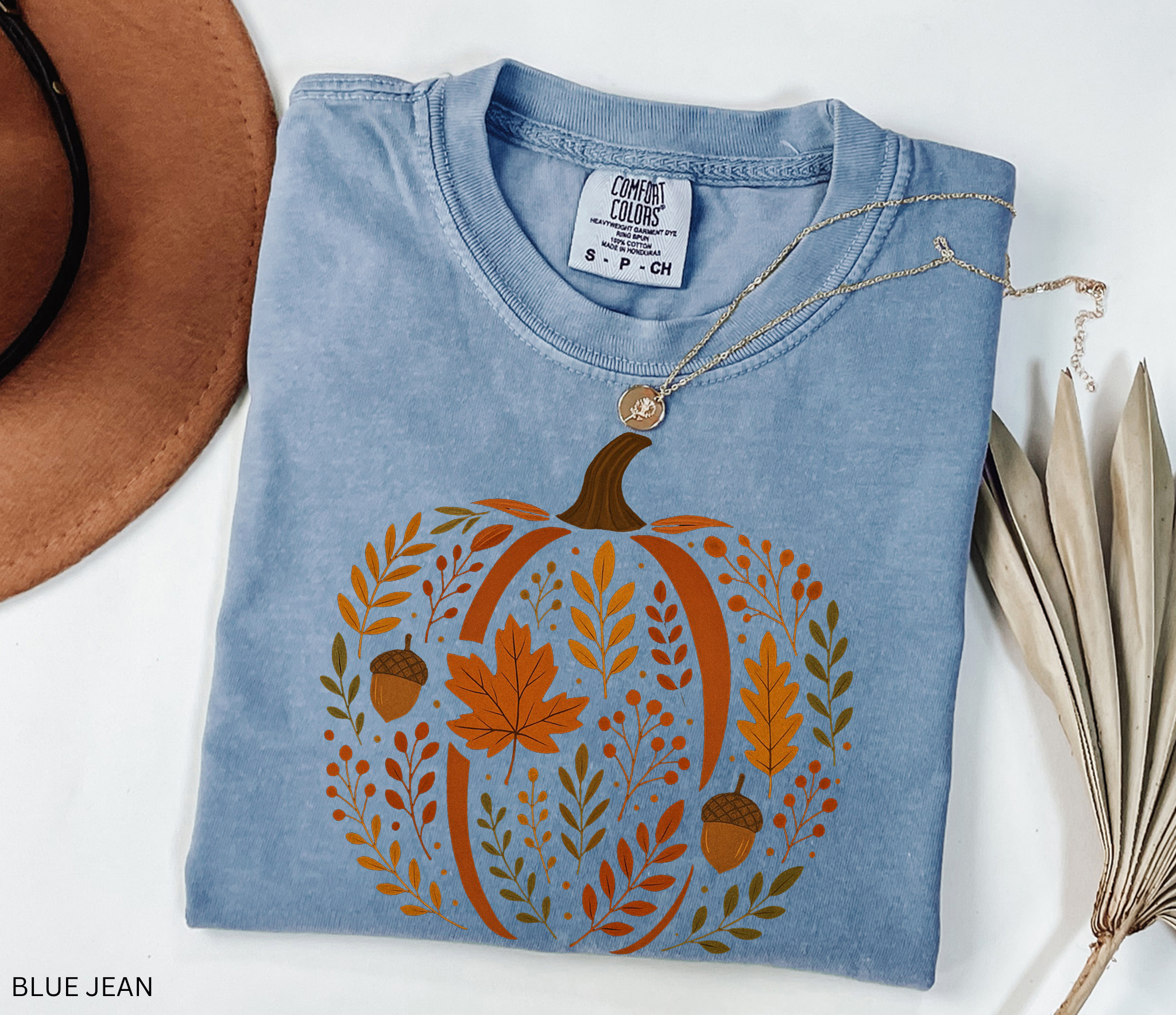 Rustic pumpkin design filled with autumn leaves, berries, and acorns, printed as a cozy botanical fall shirt.