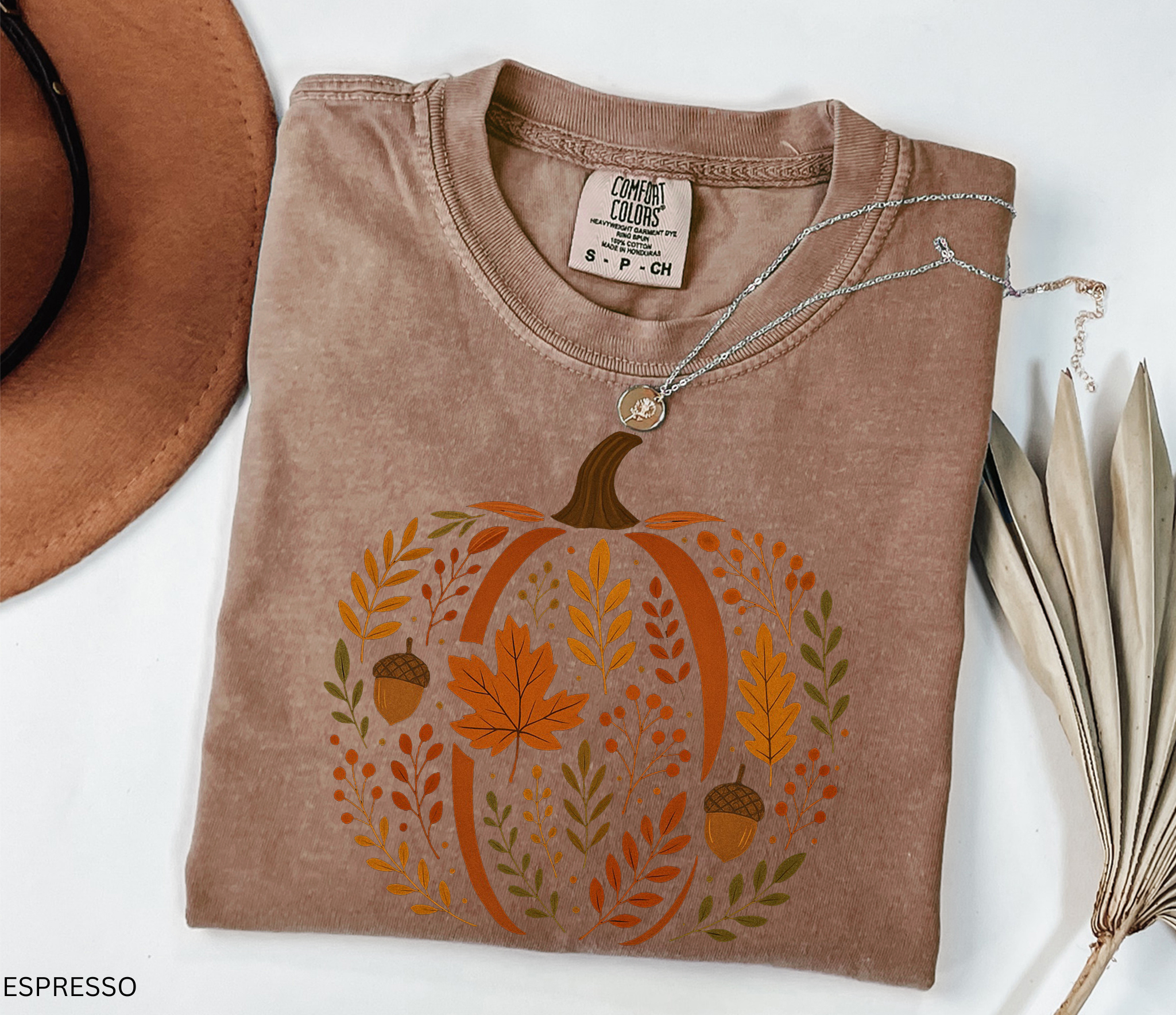 Rustic pumpkin design filled with autumn leaves, berries, and acorns, printed as a cozy botanical fall shirt.