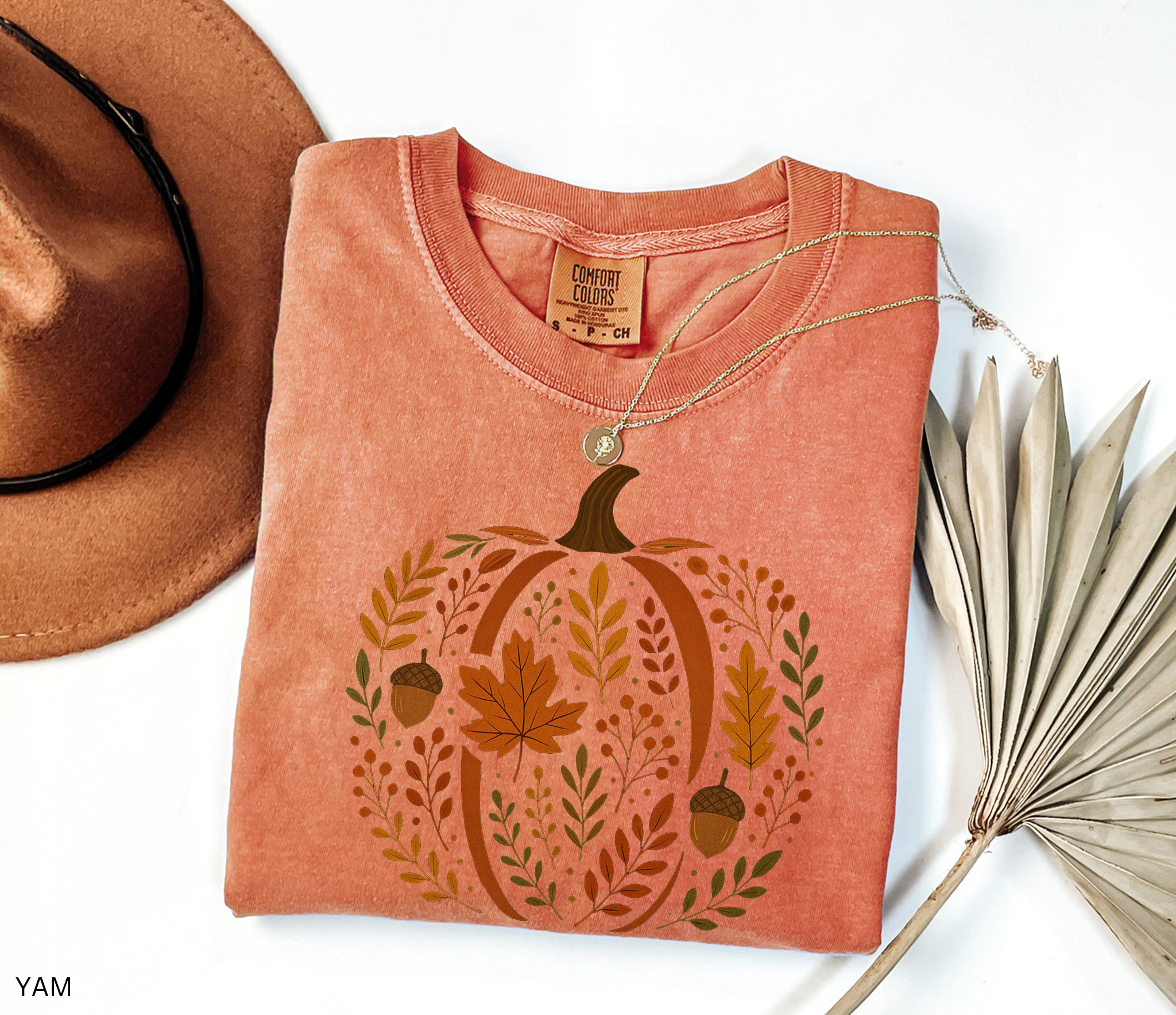 Rustic pumpkin design filled with autumn leaves, berries, and acorns, printed as a cozy botanical fall shirt.