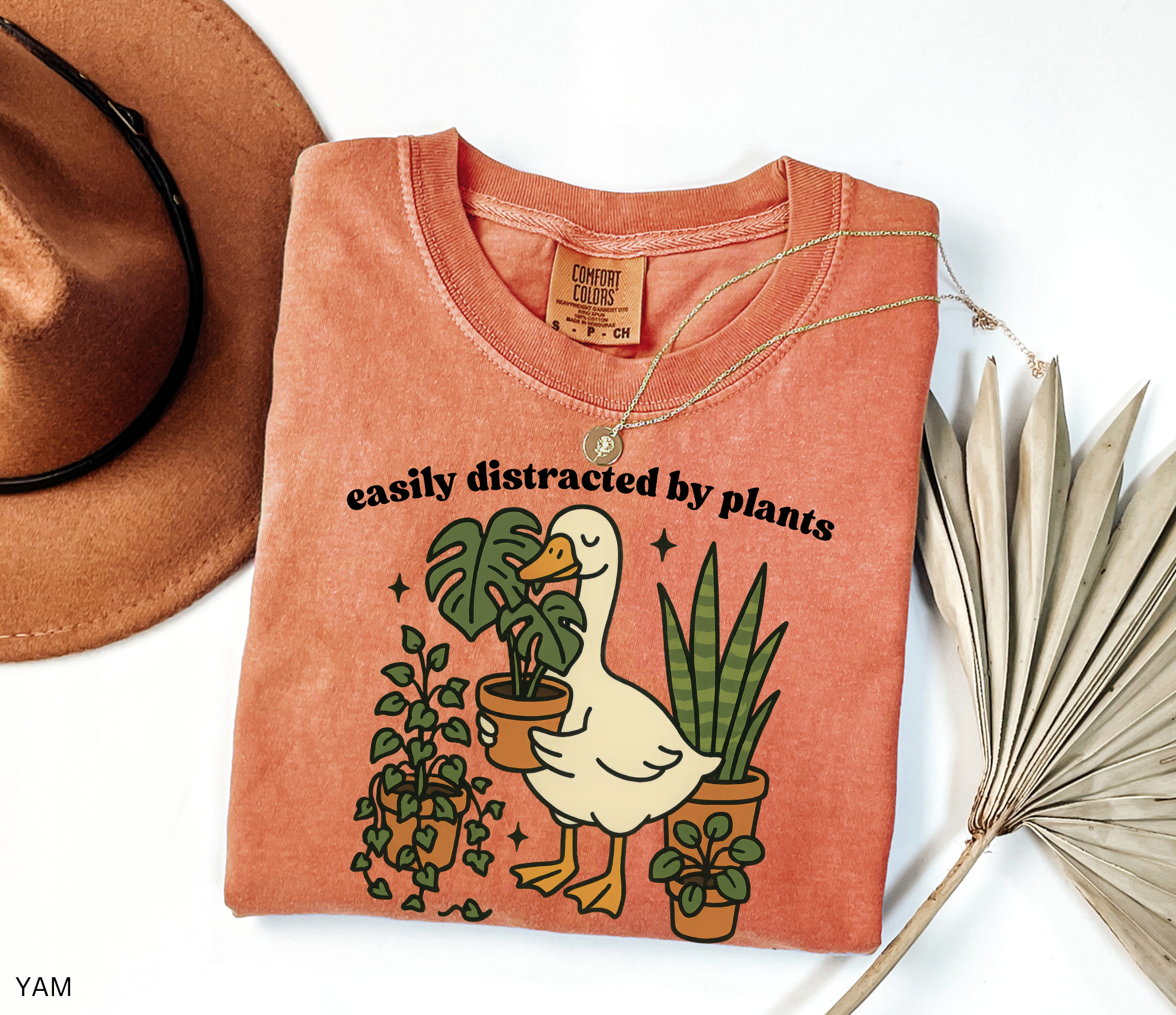 Illustration of a goose holding a monstera plant, surrounded by potted greenery including ivy, snake plants, and succulents.