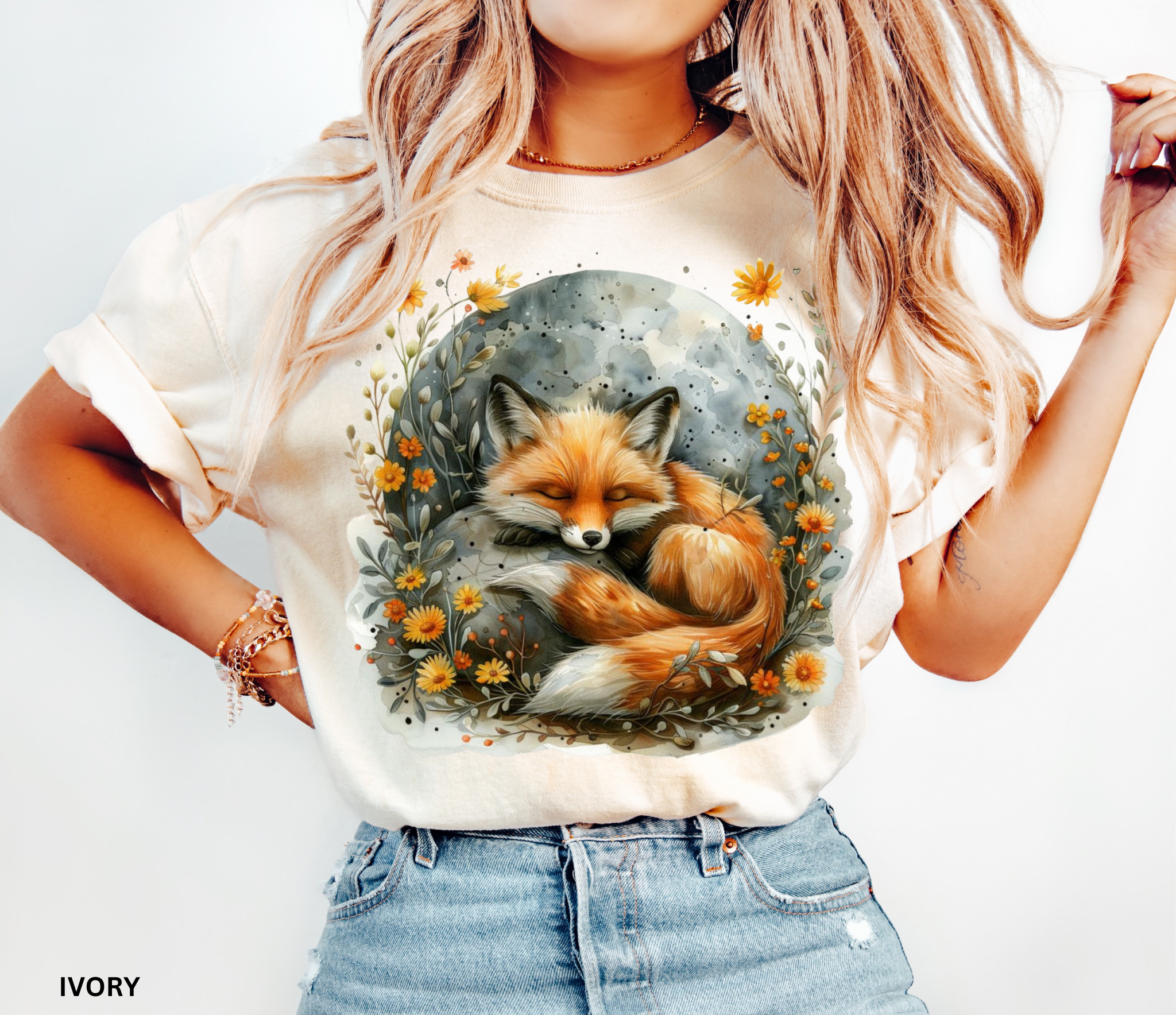 Illustration of a sleeping fox curled beneath a glowing moon, surrounded by golden wildflowers and soft foliage on a cottagecore shirt.