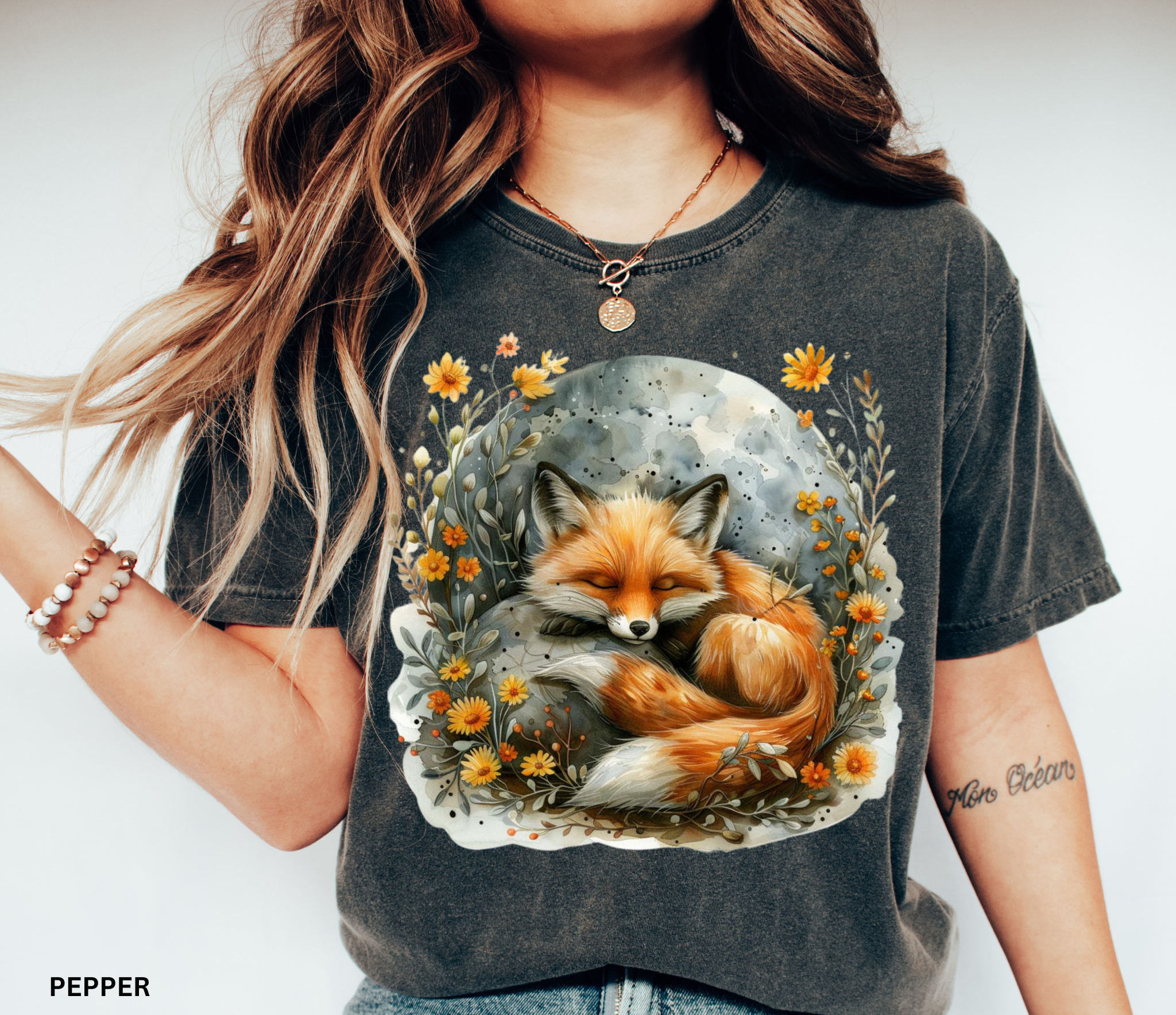 Illustration of a sleeping fox curled beneath a glowing moon, surrounded by golden wildflowers and soft foliage on a cottagecore shirt.