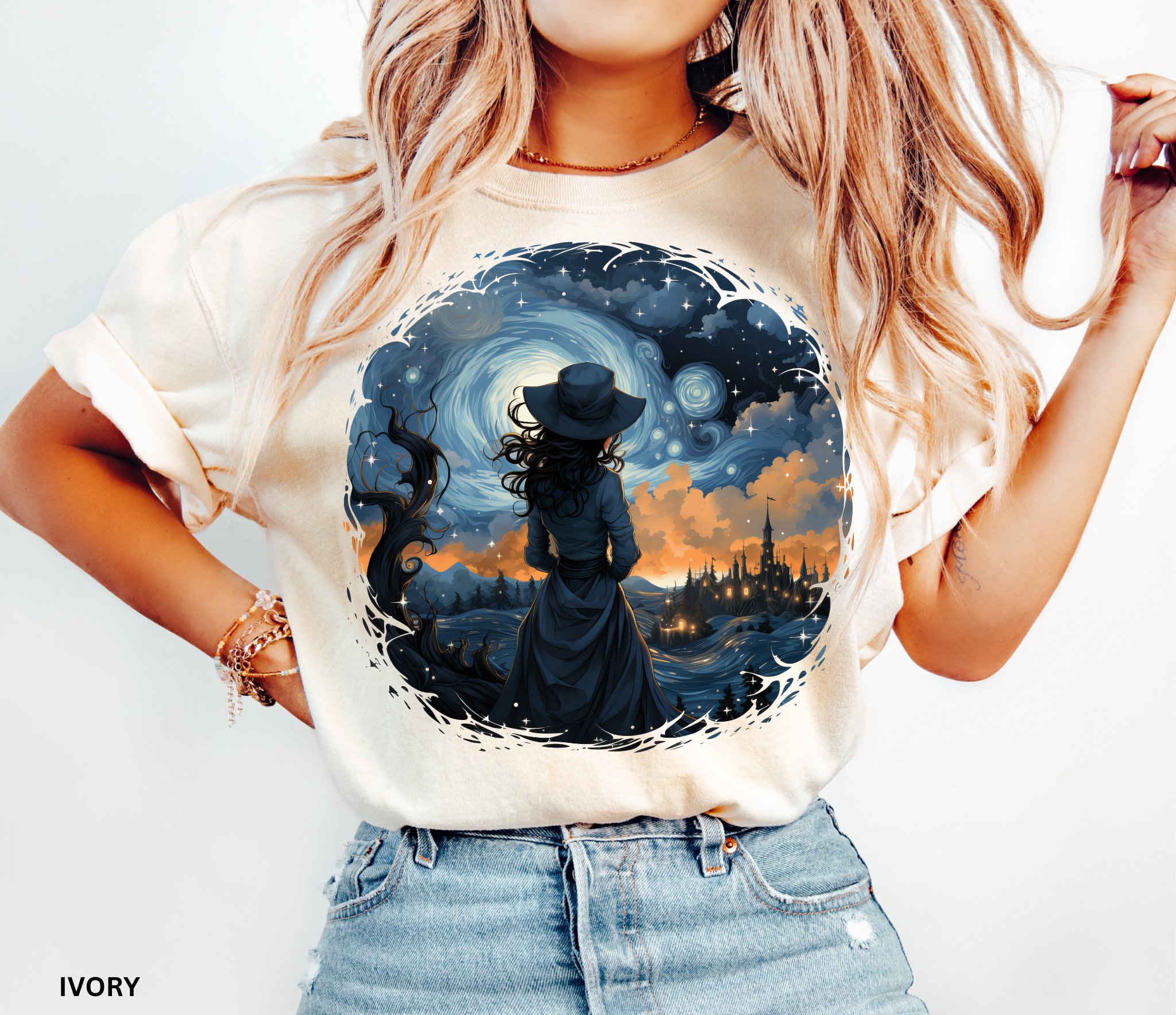 Celestial witch standing beneath swirling galaxy and glowing town – witchcore aesthetic shirt design