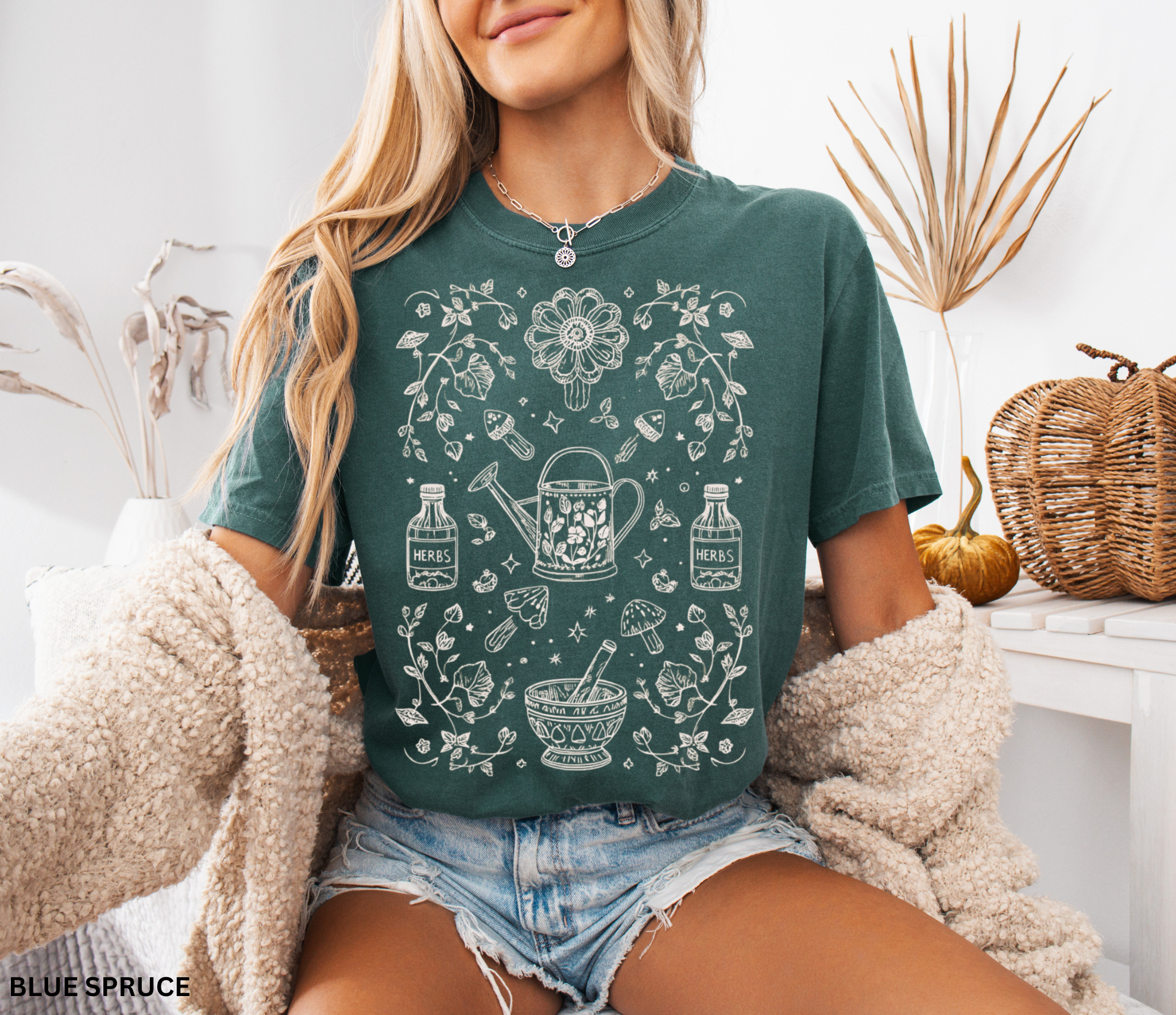 Hand-drawn herbal apothecary t-shirt featuring vintage bottles, mushrooms, watering can, and mortar and pestle — botanical witch aesthetic on Comfort Colors shirt.