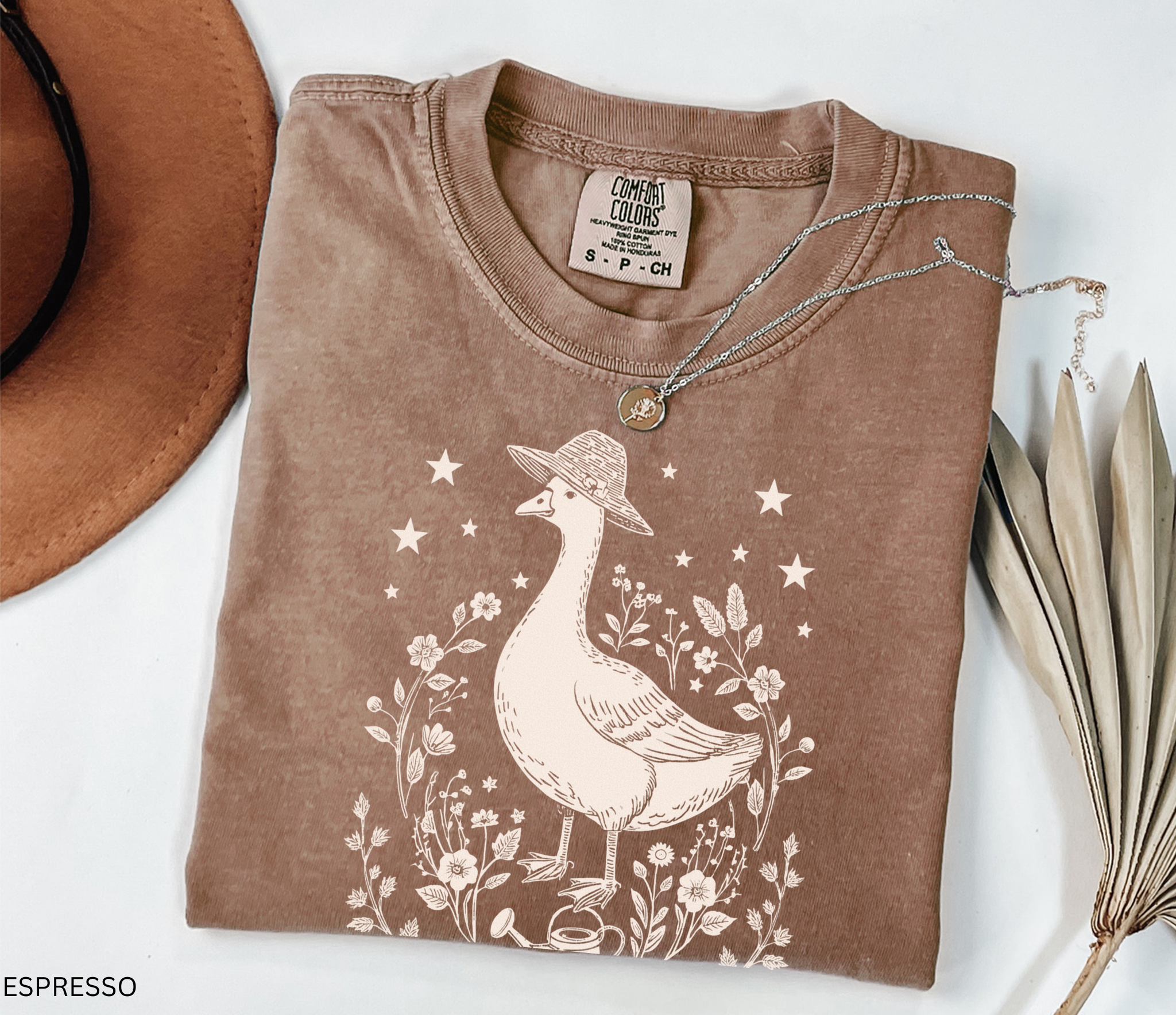 Cottagecore goose wearing hat surrounded by flowers and stars — vintage garden design printed on soft Comfort Colors shirt.