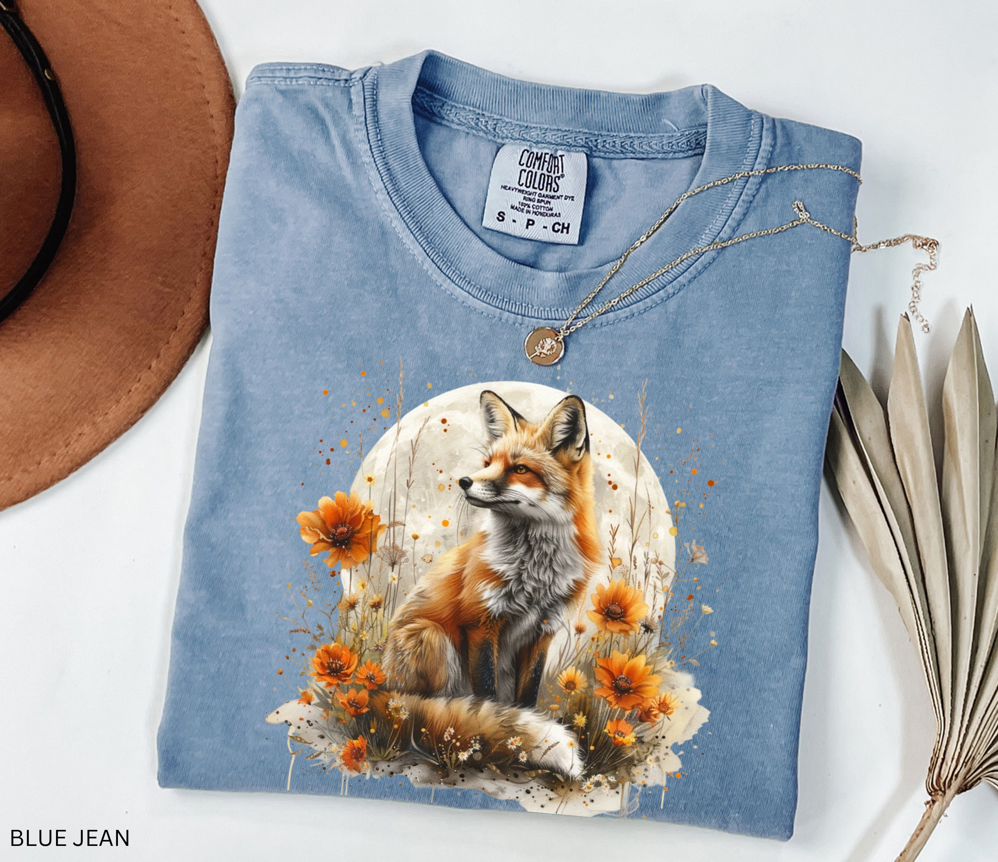 A majestic orange fox surrounded by golden wildflowers beneath a full moon on a soft Comfort Colors shirt.