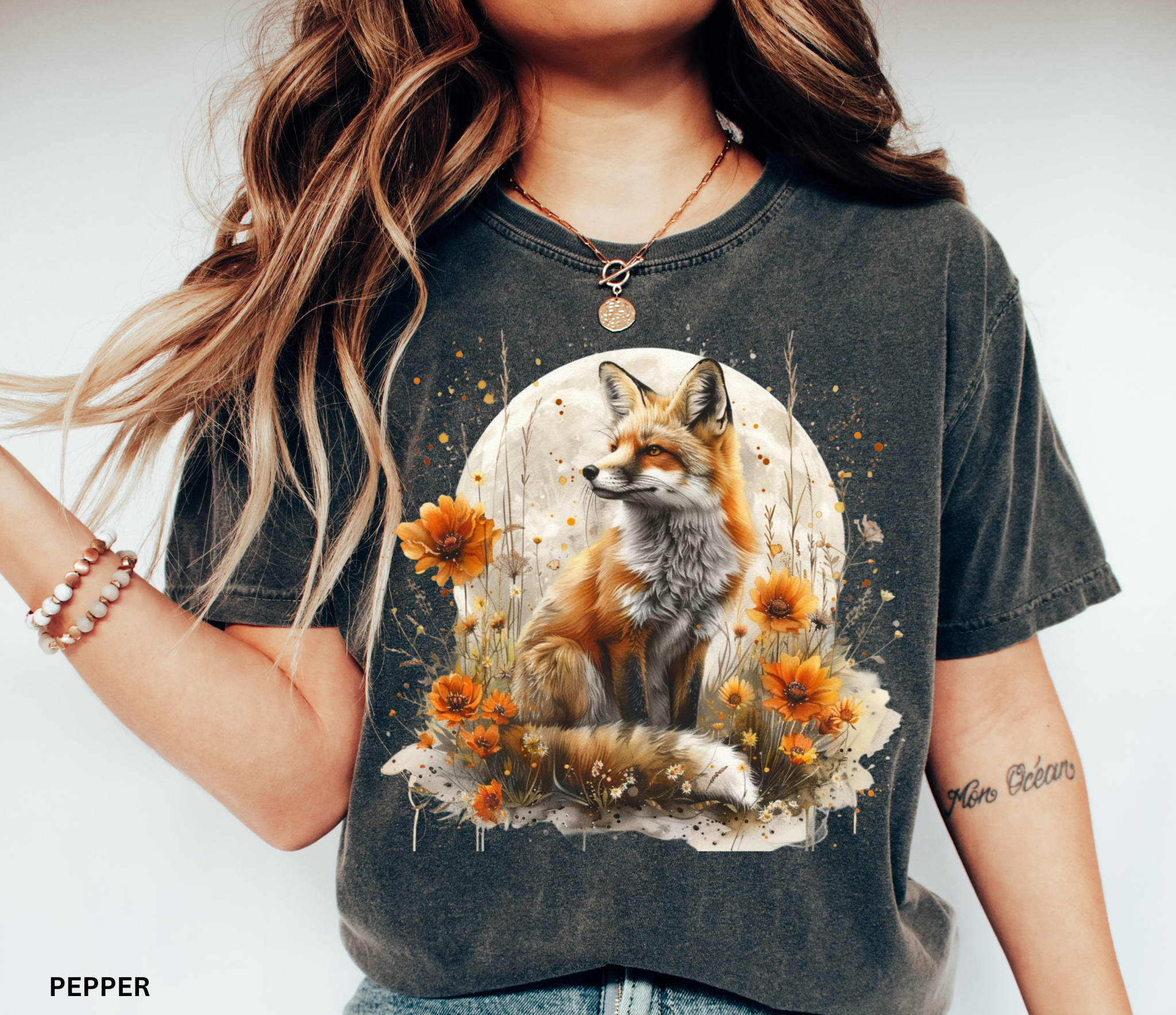 A majestic orange fox surrounded by golden wildflowers beneath a full moon on a soft Comfort Colors shirt.