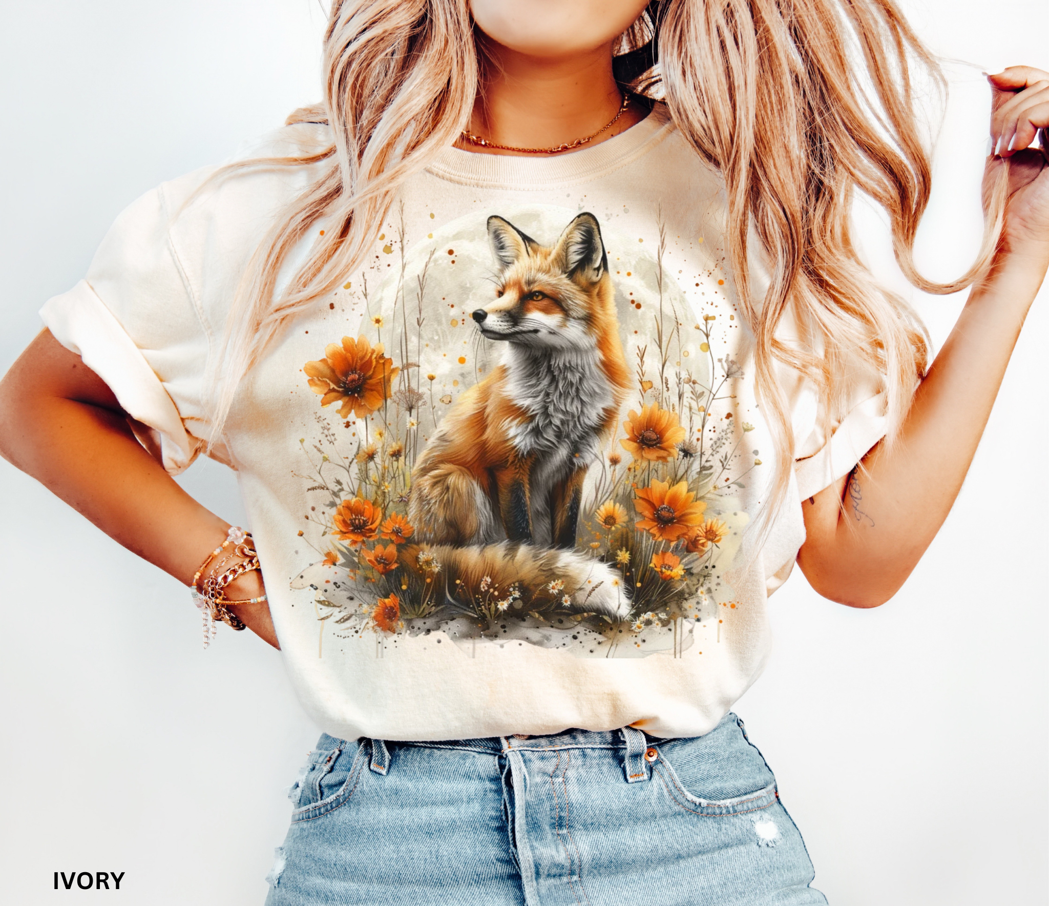 A majestic orange fox surrounded by golden wildflowers beneath a full moon on a soft Comfort Colors shirt.