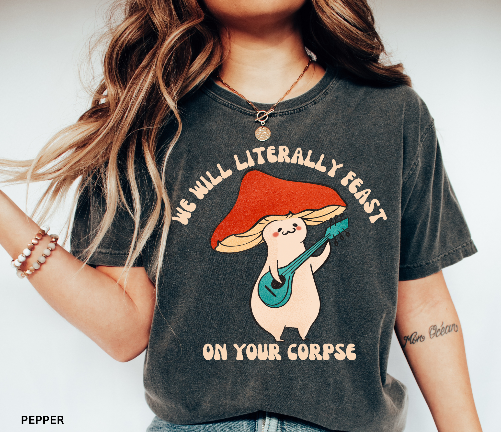 Cute cartoon mushroom playing guitar under a red cap with the quote “We Will Literally Feast on Your Corpse,” printed on a Comfort Colors tee.