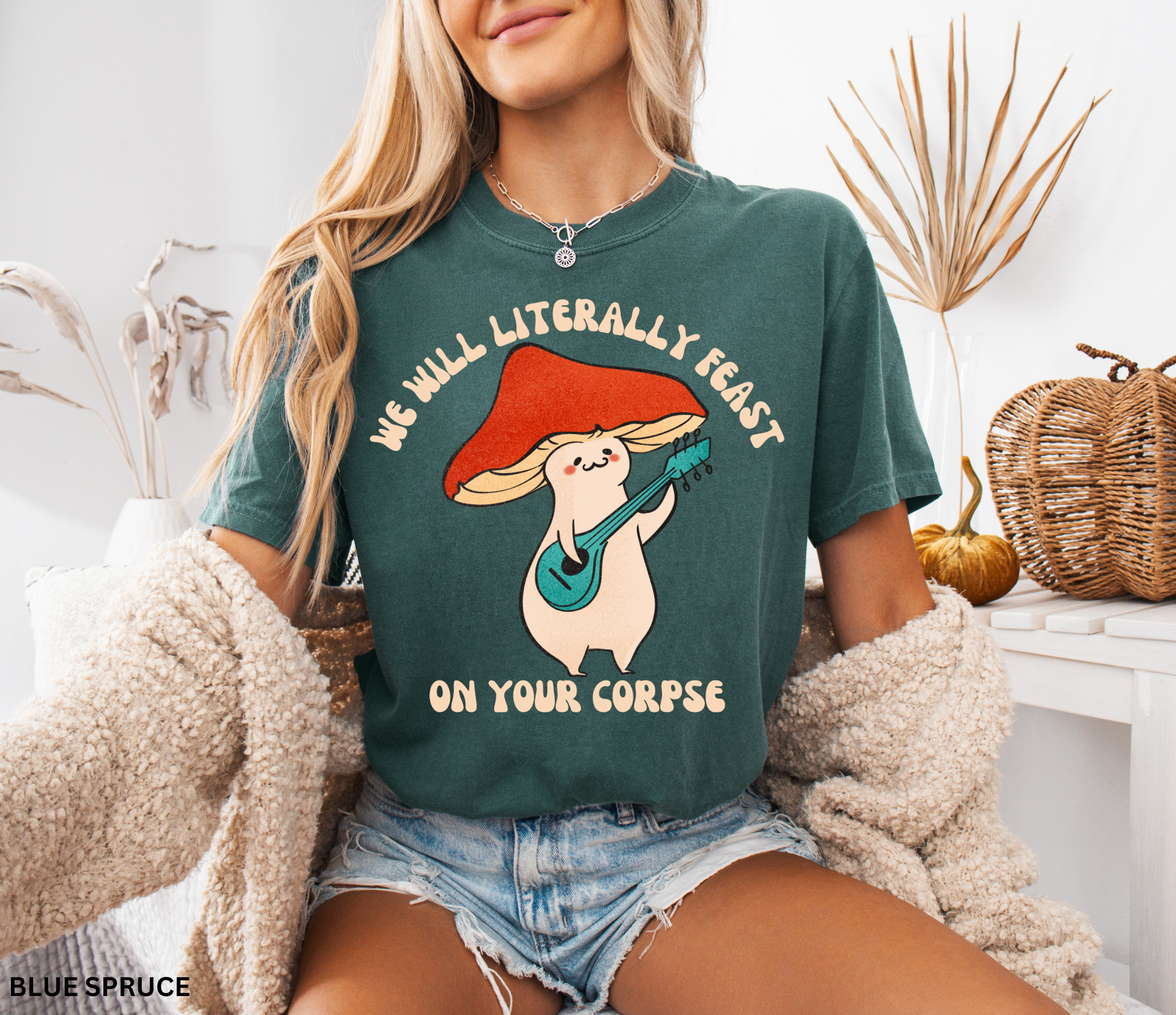 Cute cartoon mushroom playing guitar under a red cap with the quote “We Will Literally Feast on Your Corpse,” printed on a Comfort Colors tee.