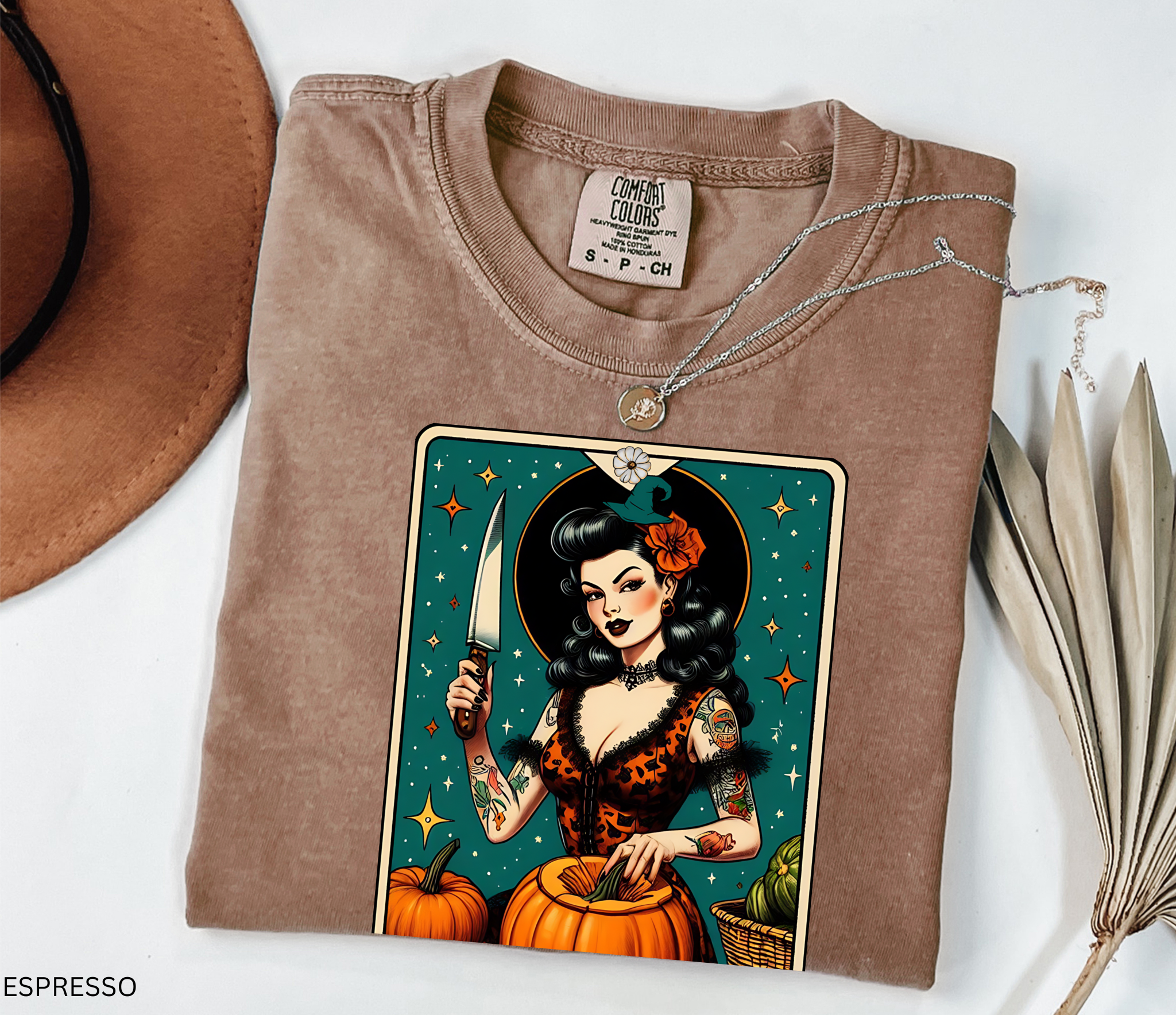 Vintage pin-up witch carving pumpkins under stars in a tarot-style design titled “The Gourd Witch.”